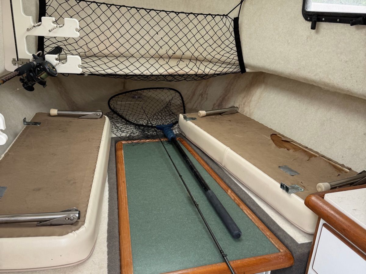 Interior of a 2001 Trophy 2509 Walkaround with fishing rods and net.