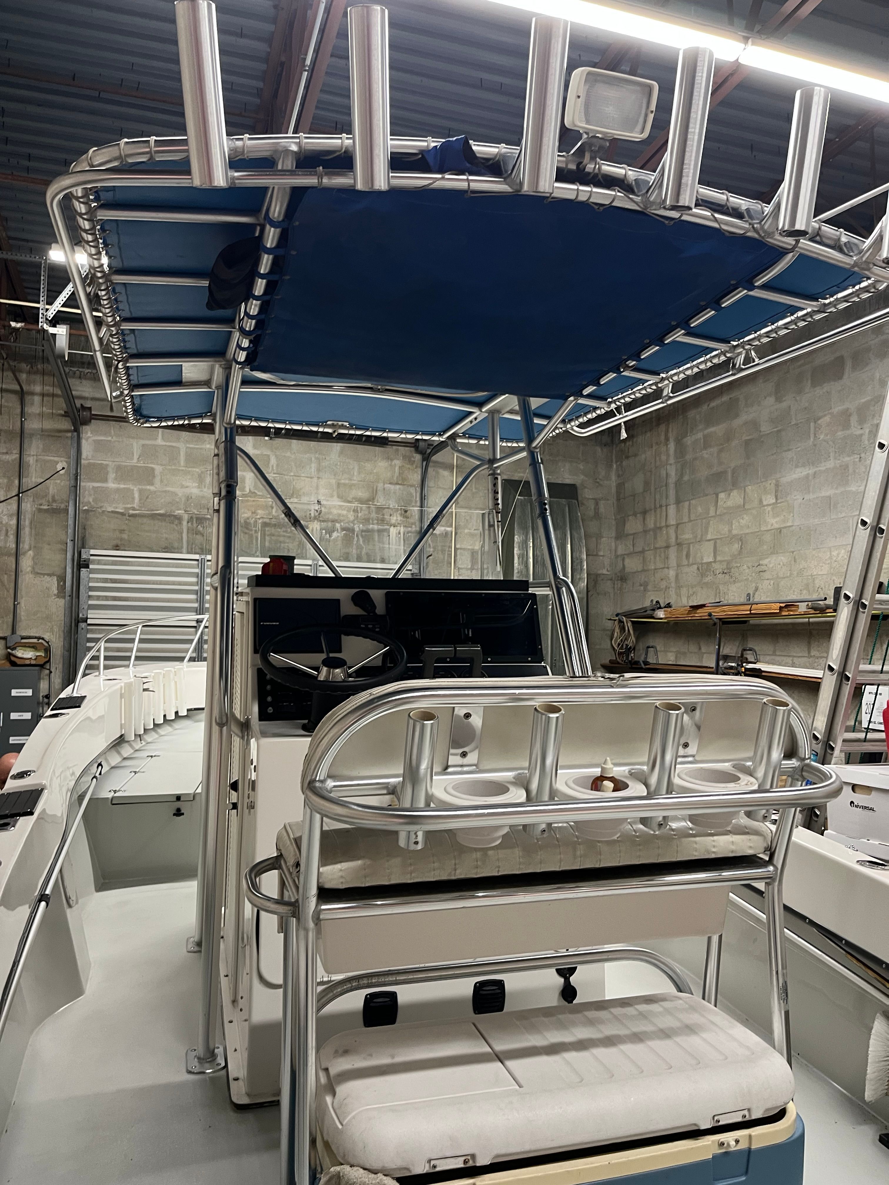 The image shows the cockpit of a 2002 Dusky 25.6 boat in a warehouse.