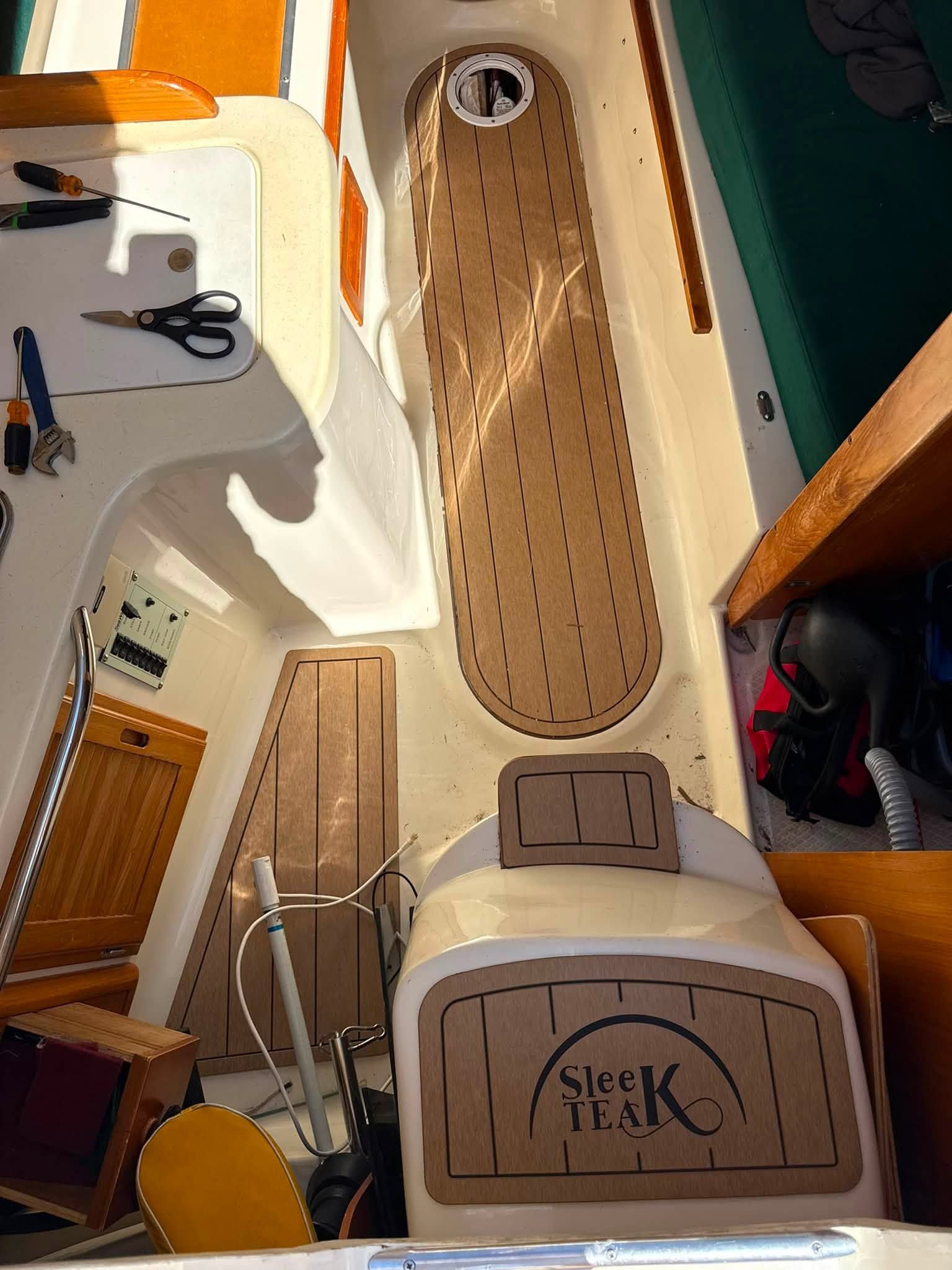 The cockpit of a 2003 Seaward 25 with wooden flooring and tools.