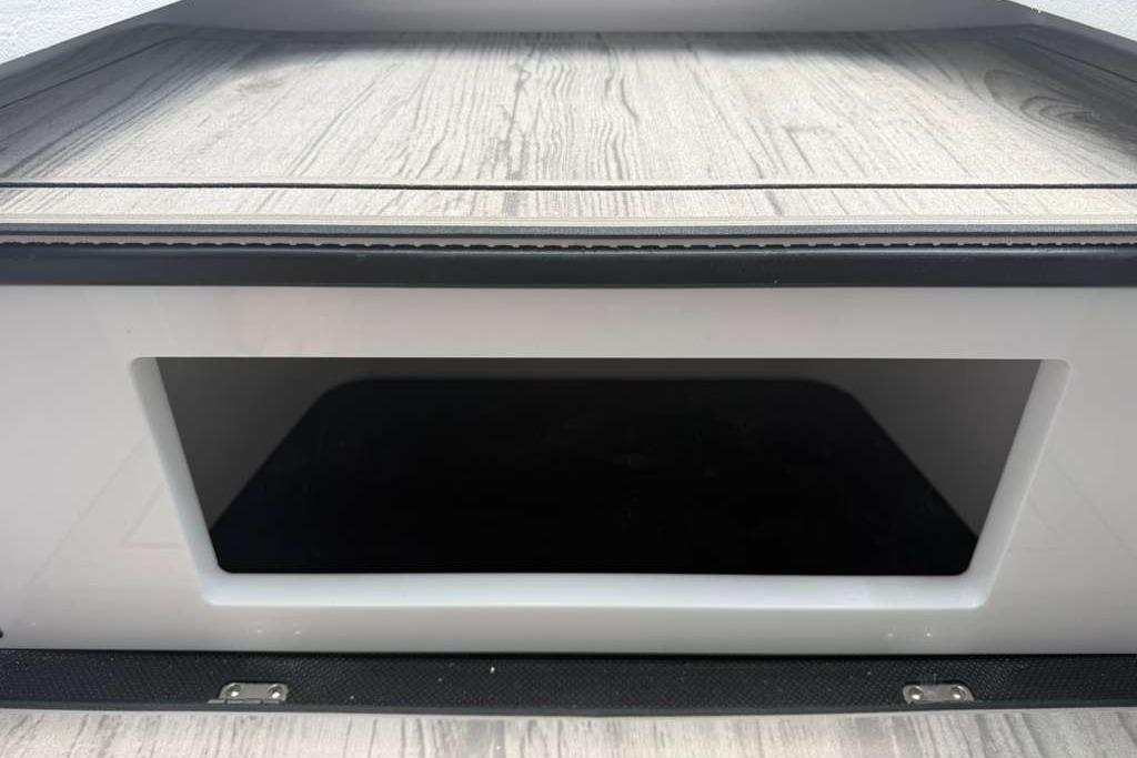 Storage compartment of a 2026 Monterey Elite 30 OB boat with wood-textured flooring.