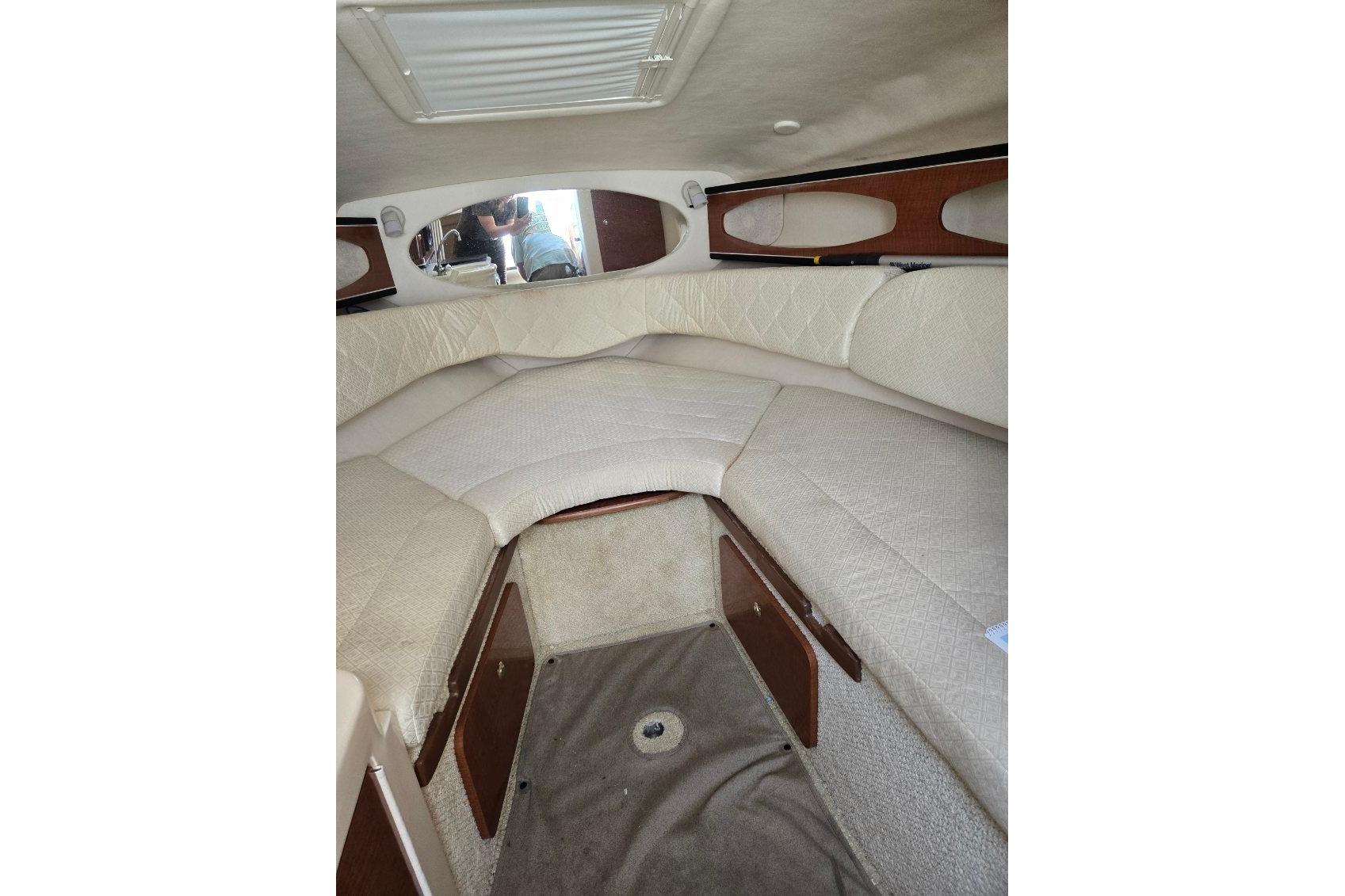 Interior cabin of 2004 Sea Ray Sundancer 260 with beige upholstery and storage compartments.