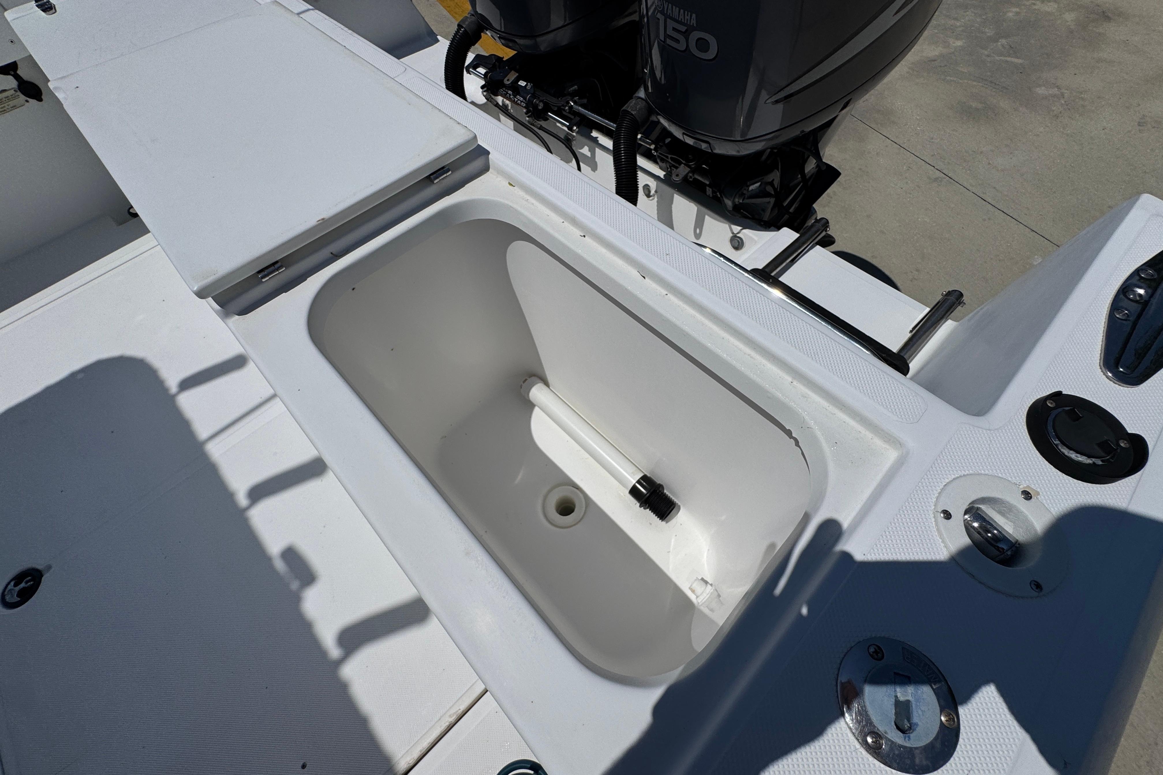 Open storage compartment on a 2000 Stamas 250 Tarpon boat deck.