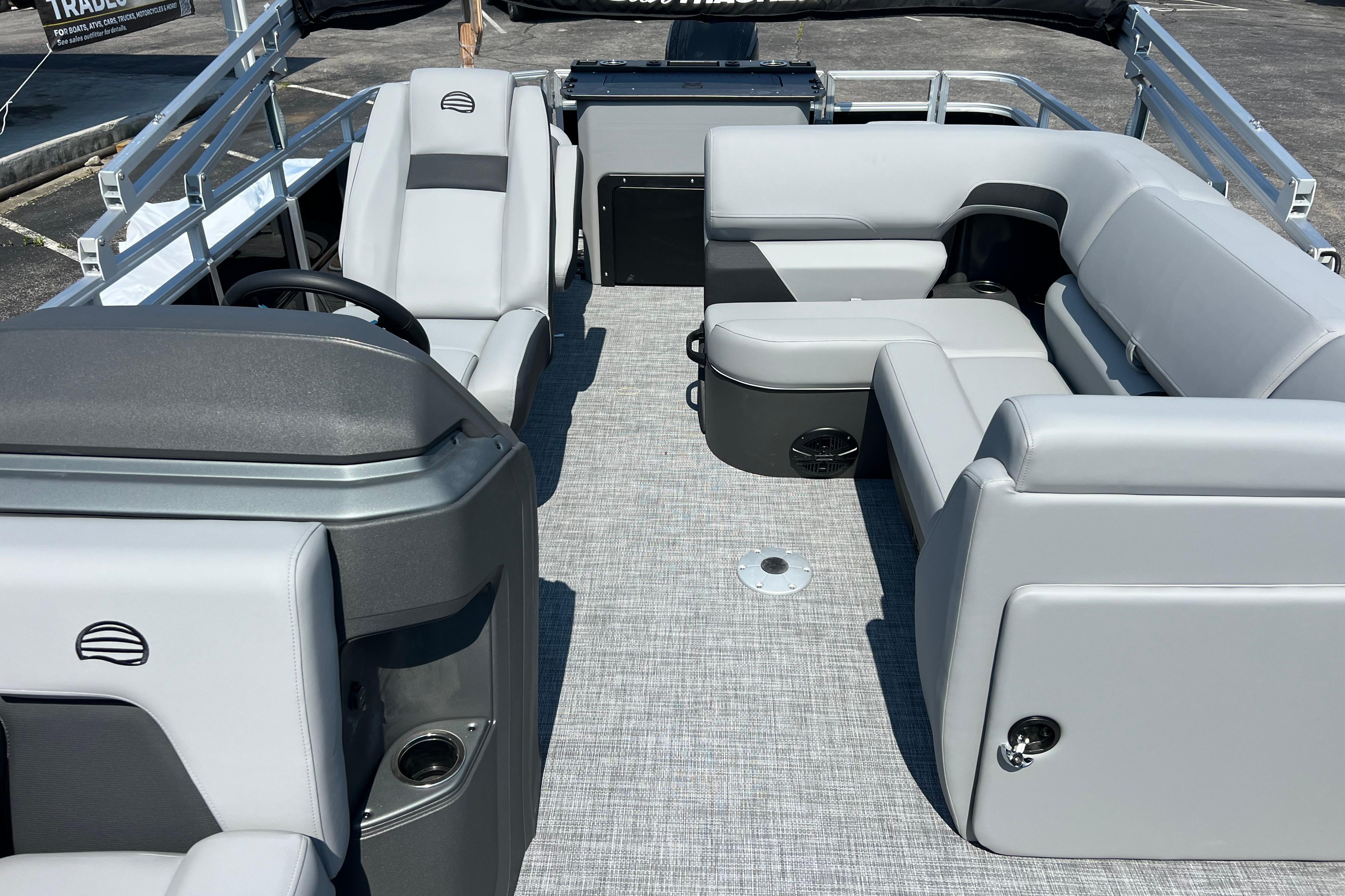 2026 Sun Tracker SportFish 20 DLX pontoon boat interior with gray seating and steering console.
