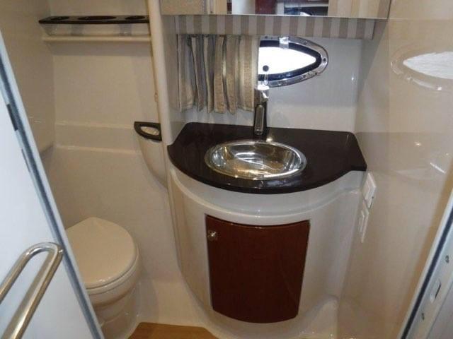 2012 Formula 34 Cruiser bathroom with sink, toilet, and porthole window.
