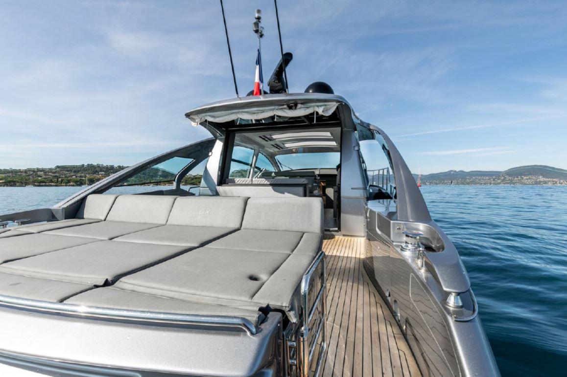 2018 Pershing 5x yacht with sun deck, sleek design, cruising on calm blue waters.