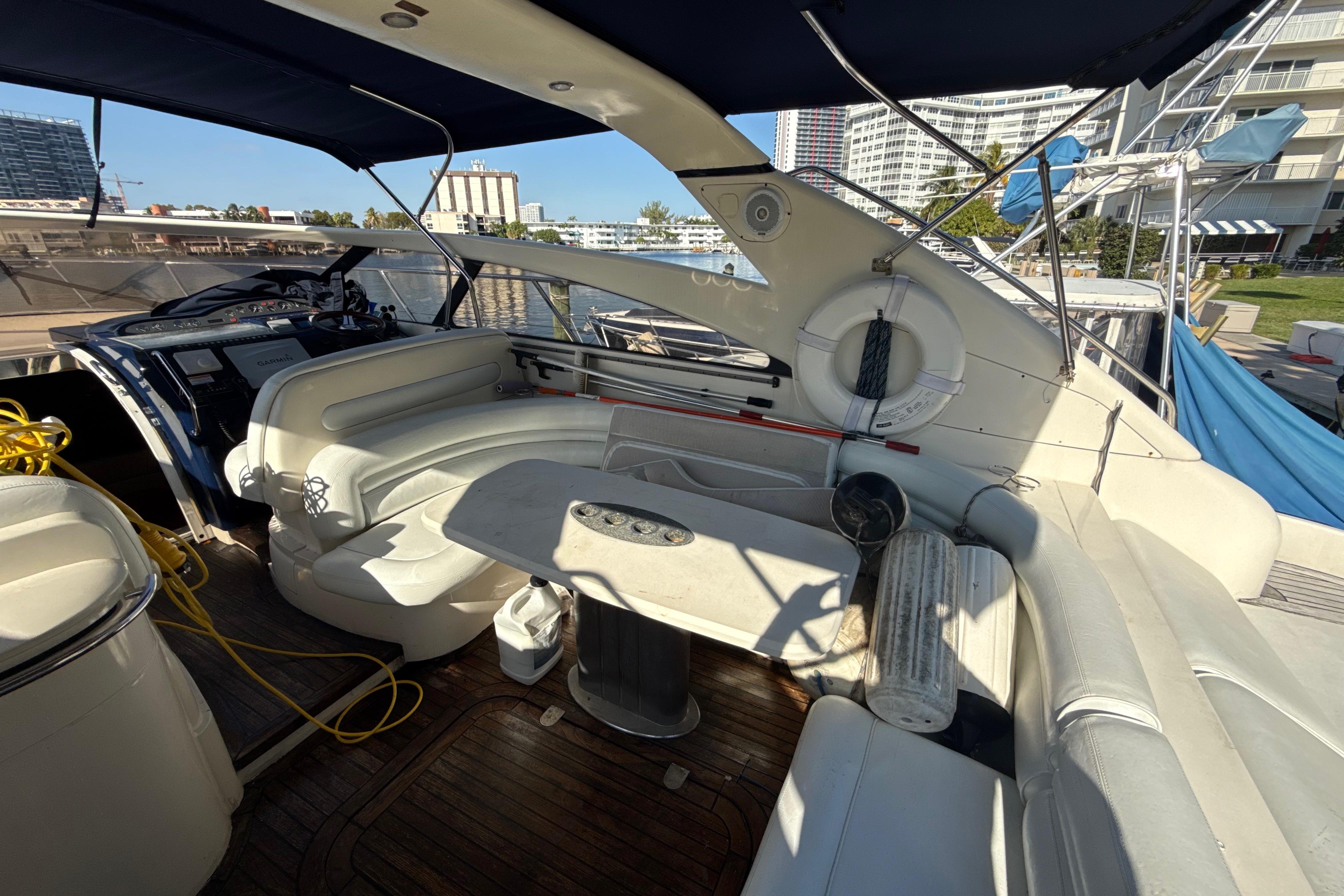 Luxurious 2002 Viking Princess V50 yacht interior with seating and table, docked at marina.