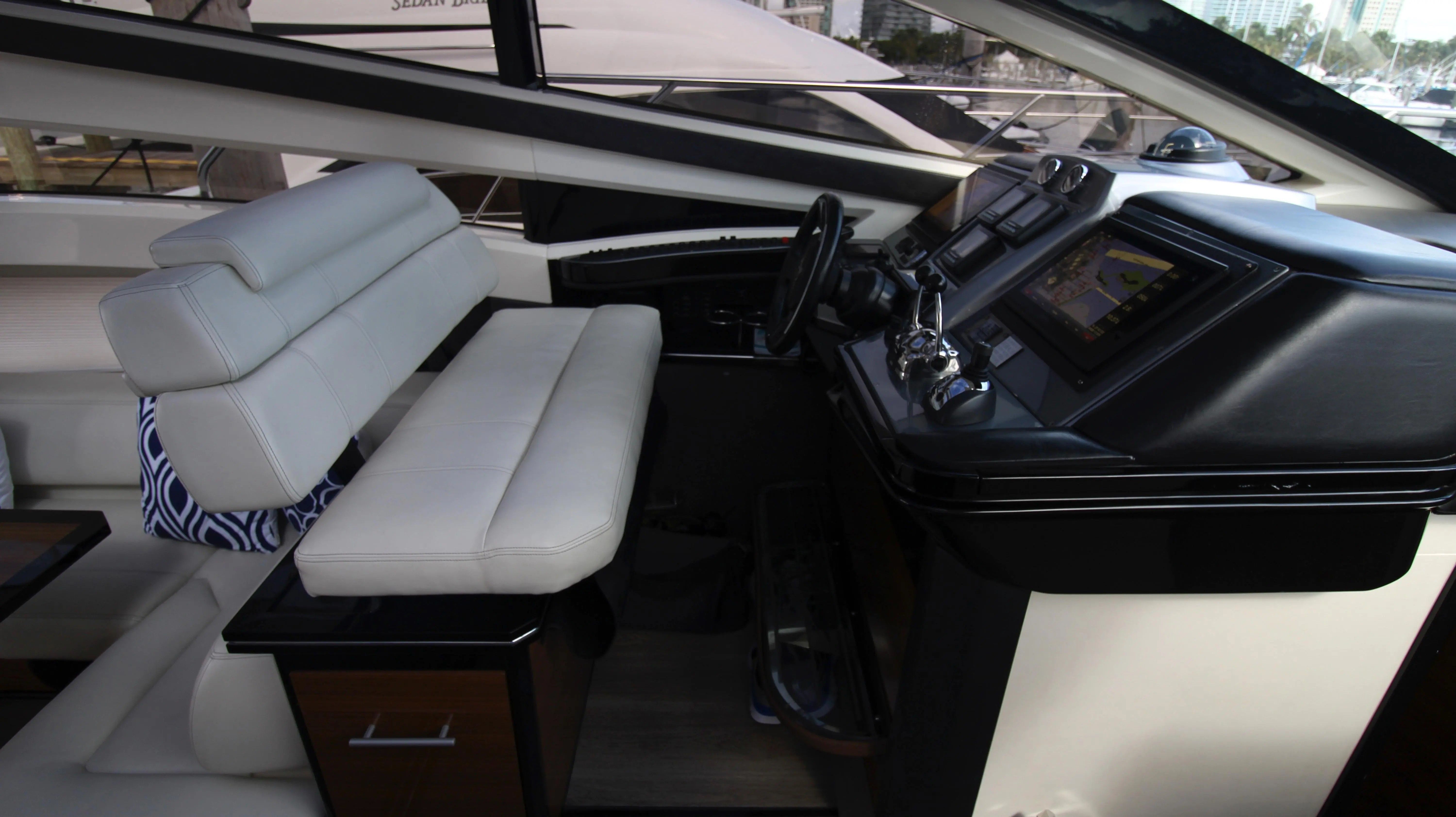 Interior of a 2010 Marquis Sport Coupe with modern helm and white leather seating.