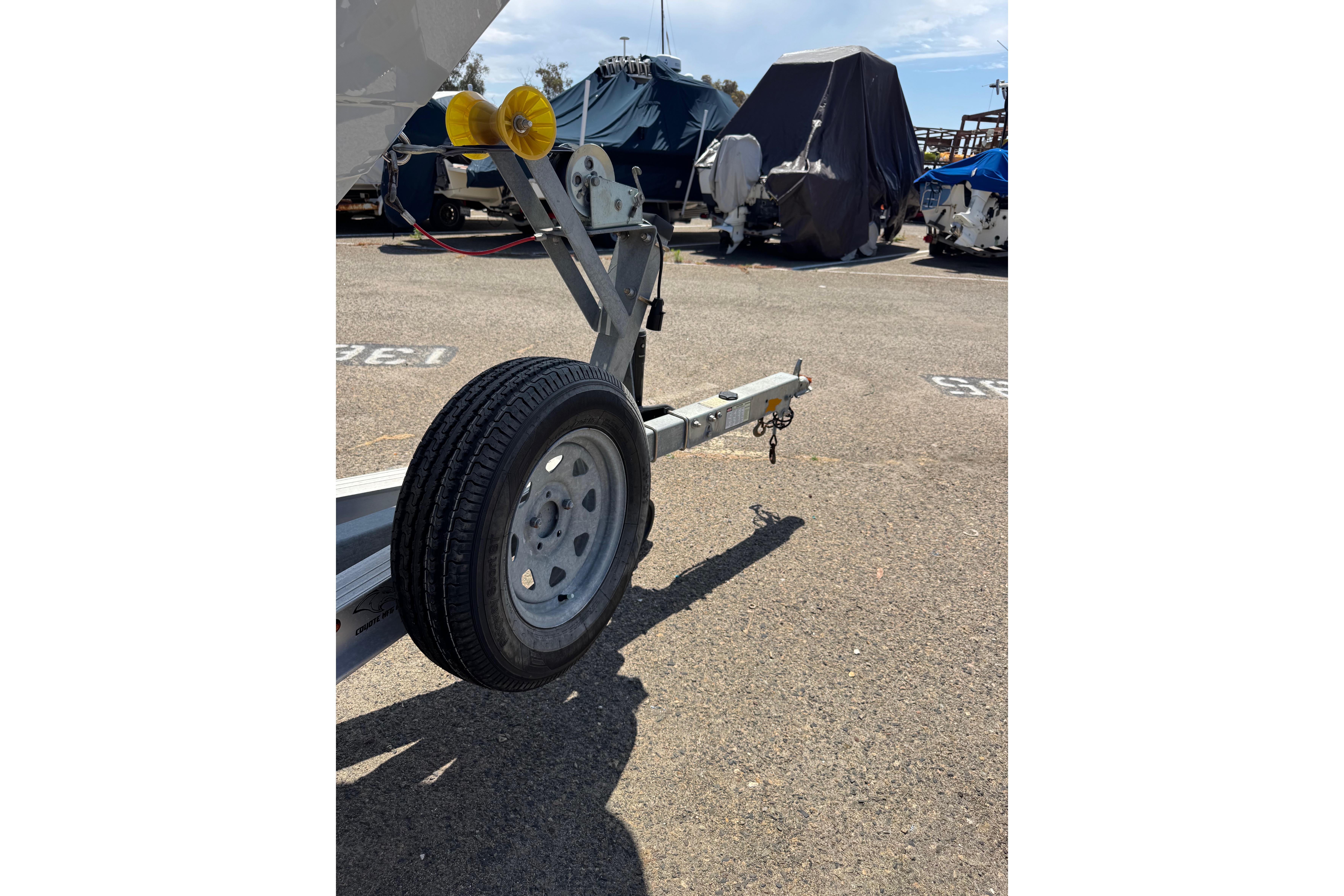 Trailer for 2022 Robalo R230 Center Console boat in parking lot.