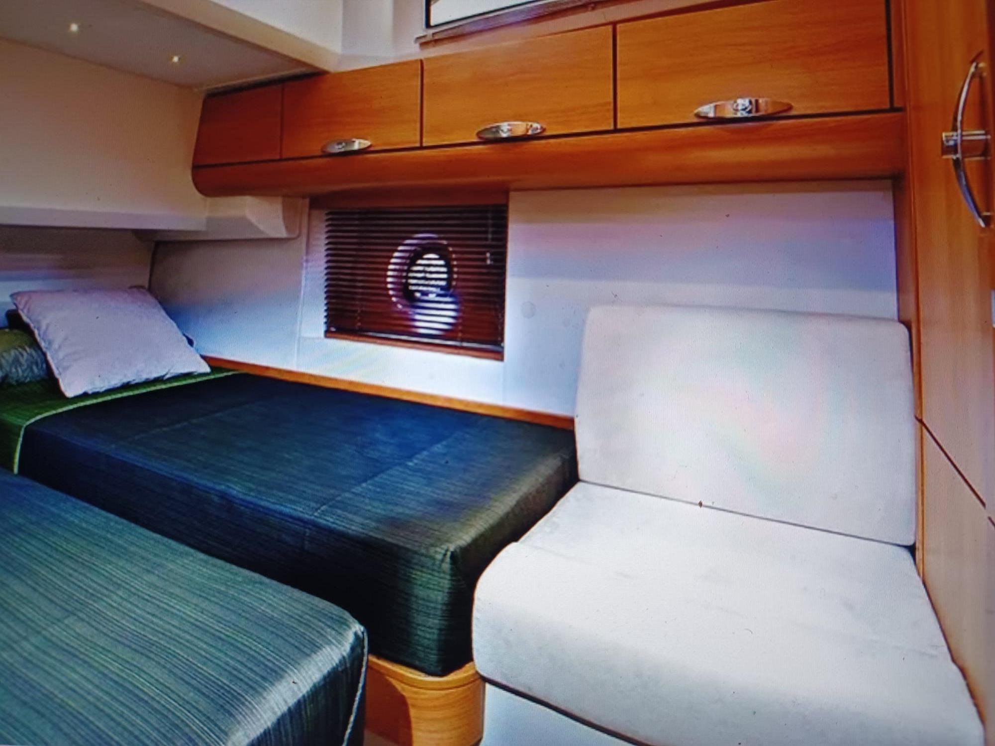 Interior of 2020 Greenline 40 yacht cabin with twin beds and wooden cabinetry.
