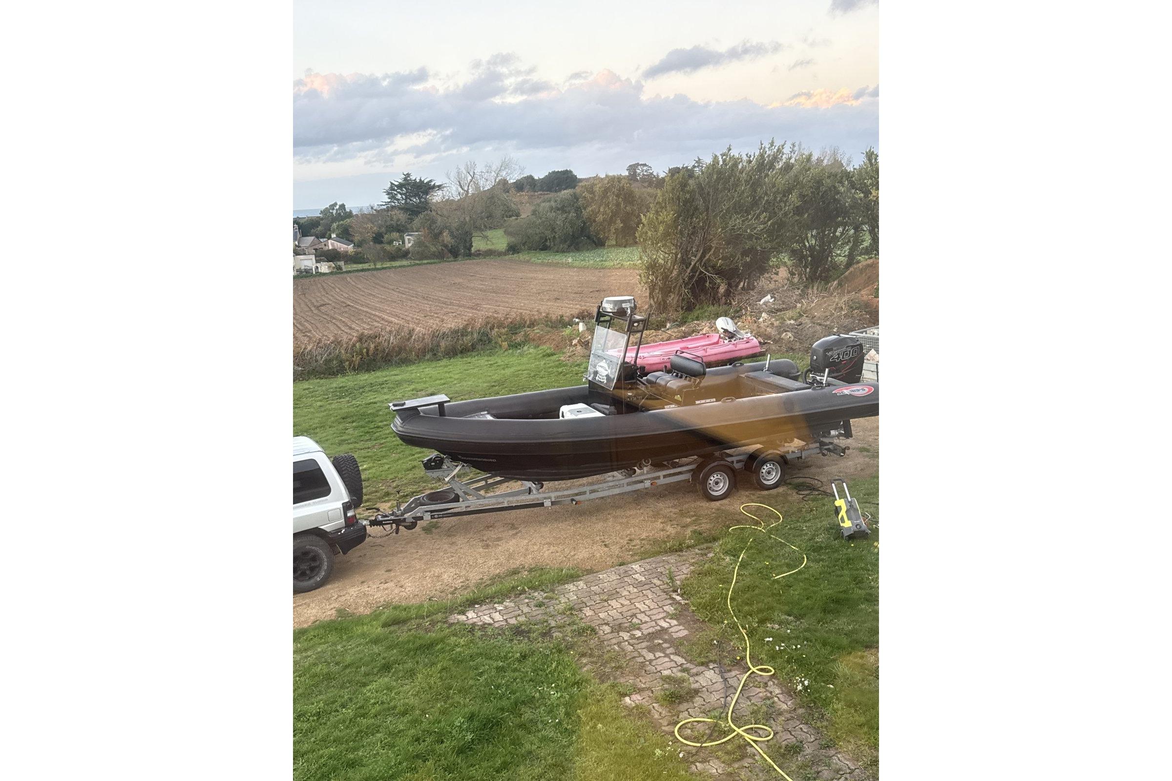 2016 Sea Ribs 760 boat on trailer, countryside background, overcast sky.