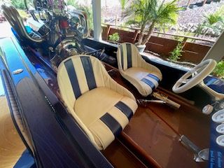 A classic 1980 Sanger HYDRO V DRIVE boat with striped seats and a powerful engine.