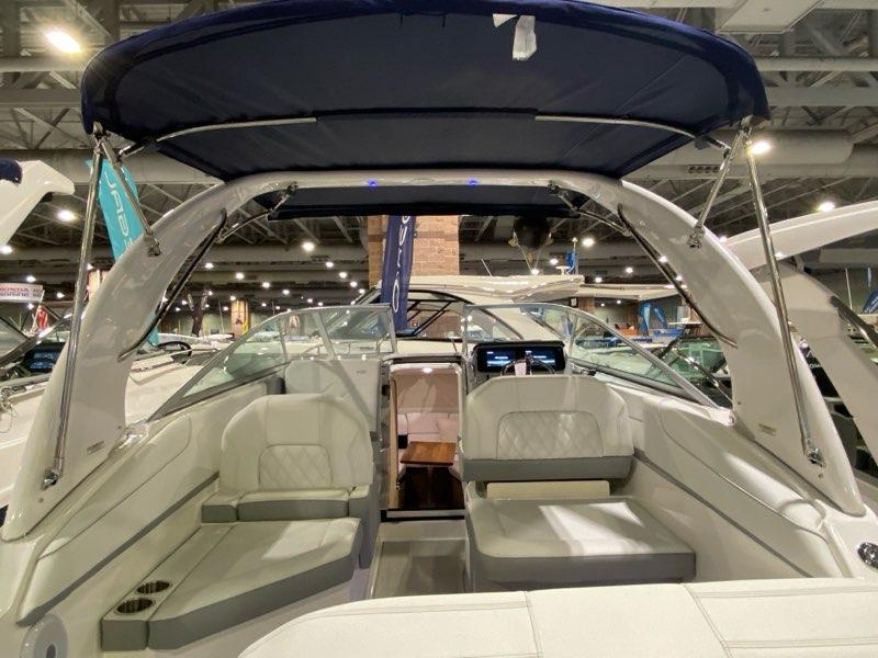 2026 Regal 26 XO boat interior with seating and canopy at an indoor exhibition.
