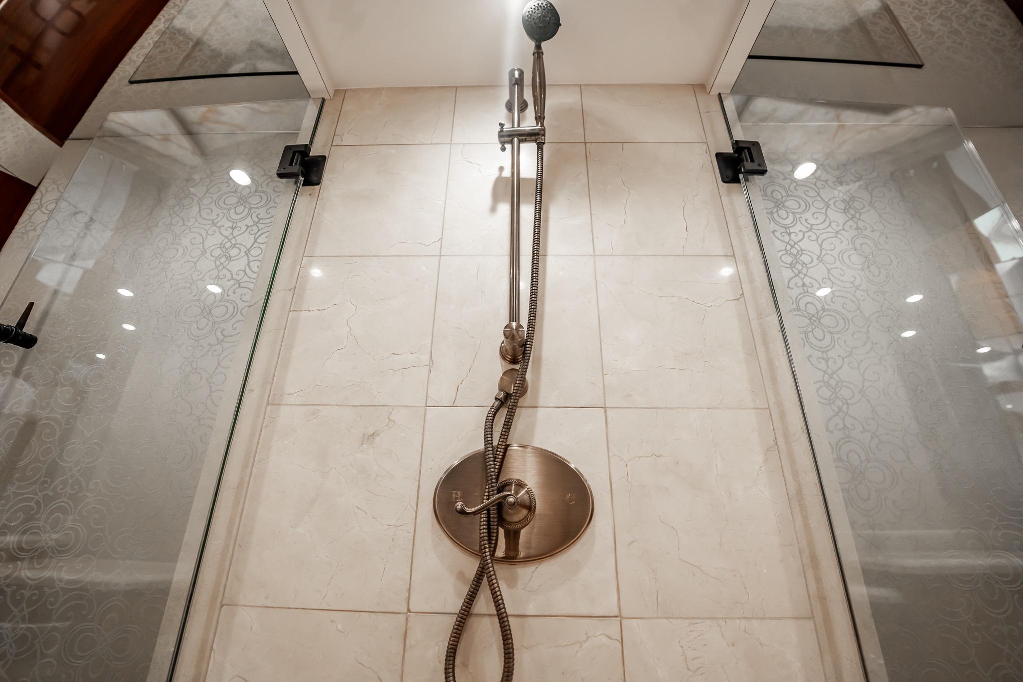 Luxurious shower in 2012 Hatteras 80 Motor Yacht with elegant glass doors and modern fixtures.