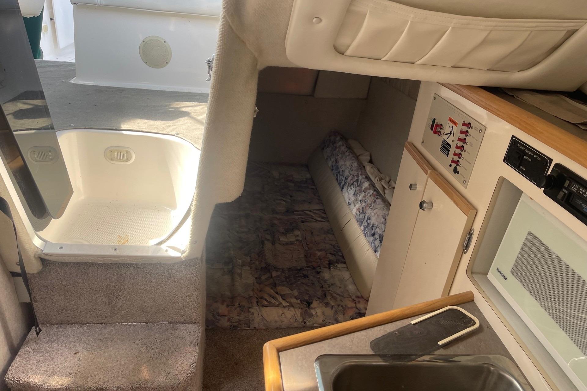 1997 Bayliner 2655 Ciera cabin interior with kitchenette, seating, and control panel.