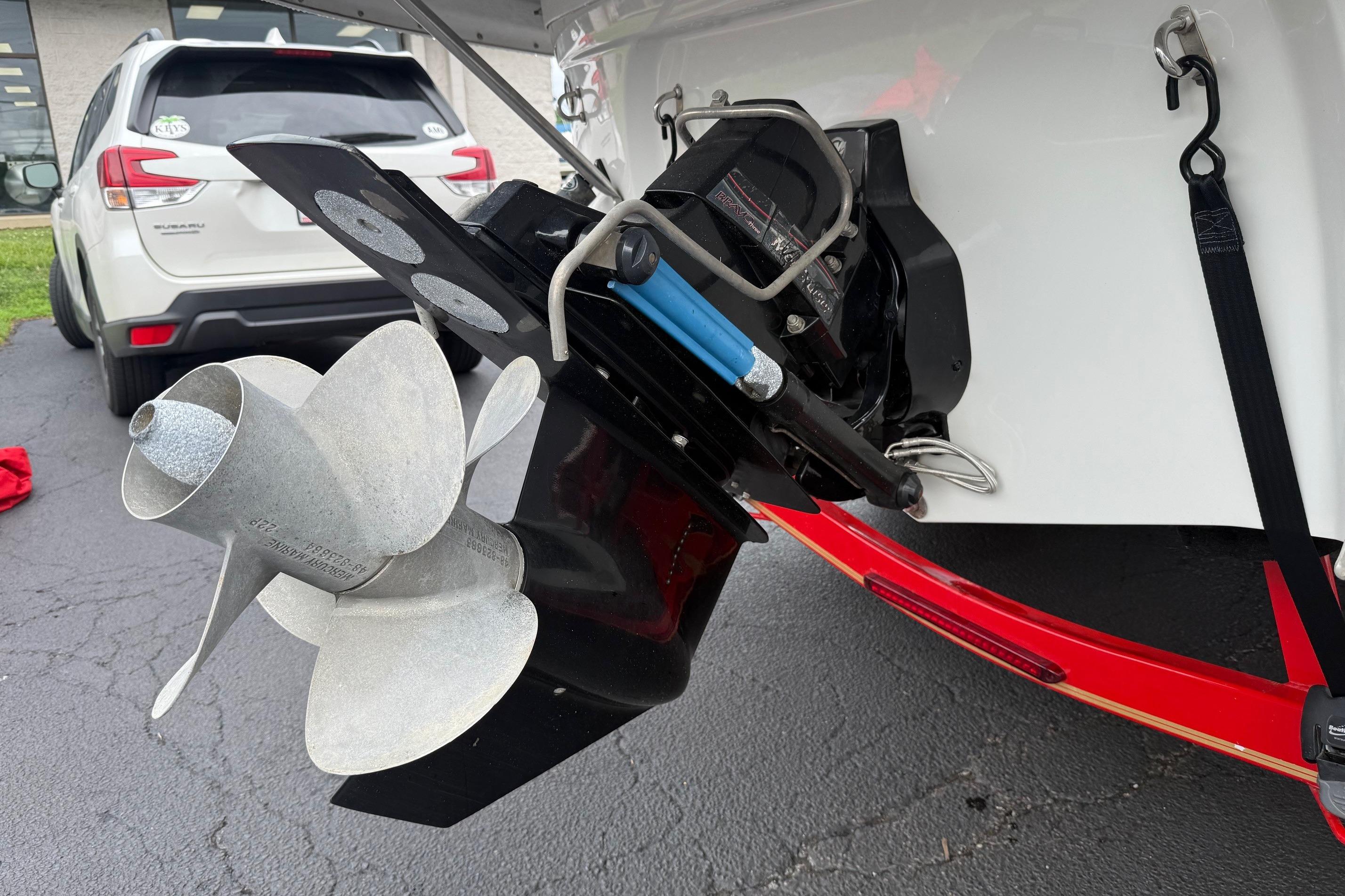 Close-up of a 2005 Crownline 250 CR boat propeller and outdrive in a parking lot.
