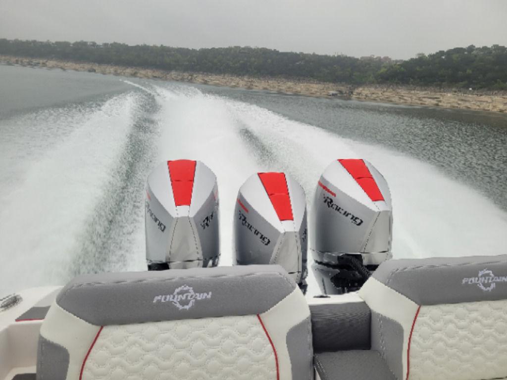 2024 Fountain 38 SCX boat with triple engines cruising on a lake.