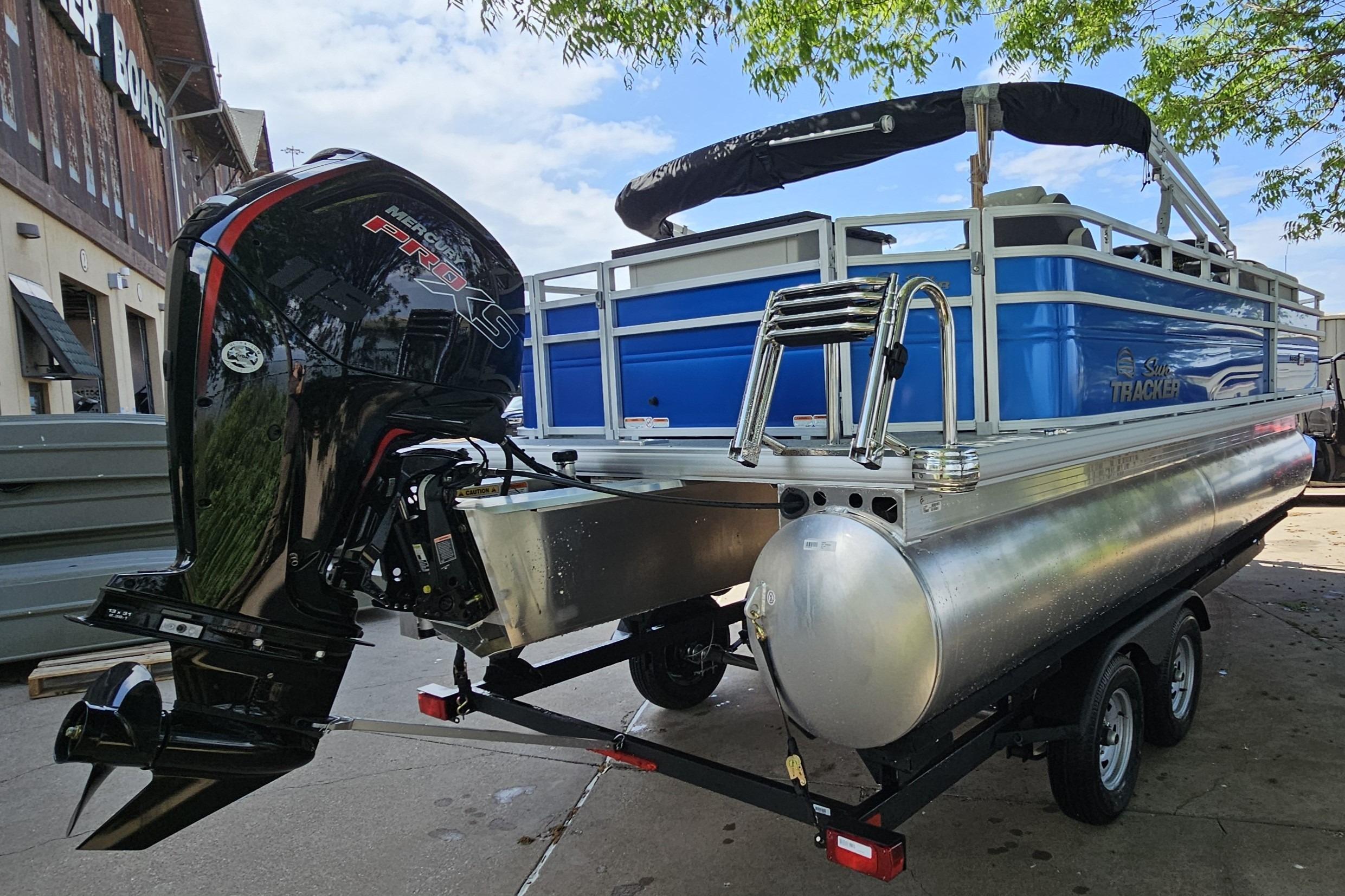 2026 Sun Tracker Fishin' Barge 20 DLX pontoon boat with powerful outboard motor.