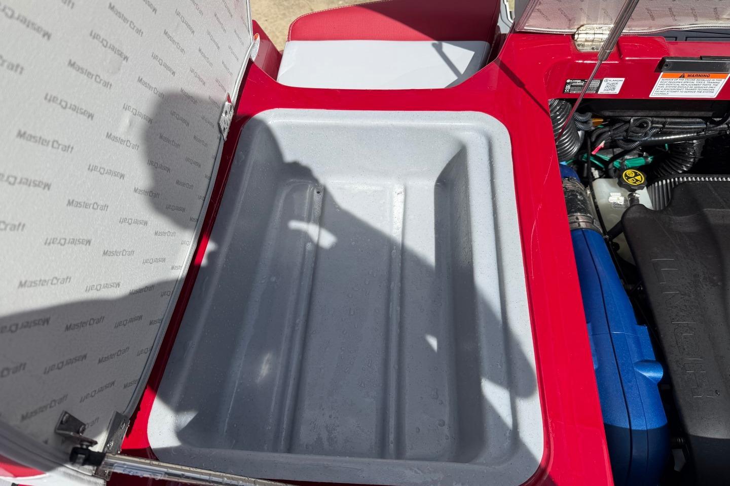 Open storage compartment in 2023 MasterCraft X24 boat, showcasing interior details.