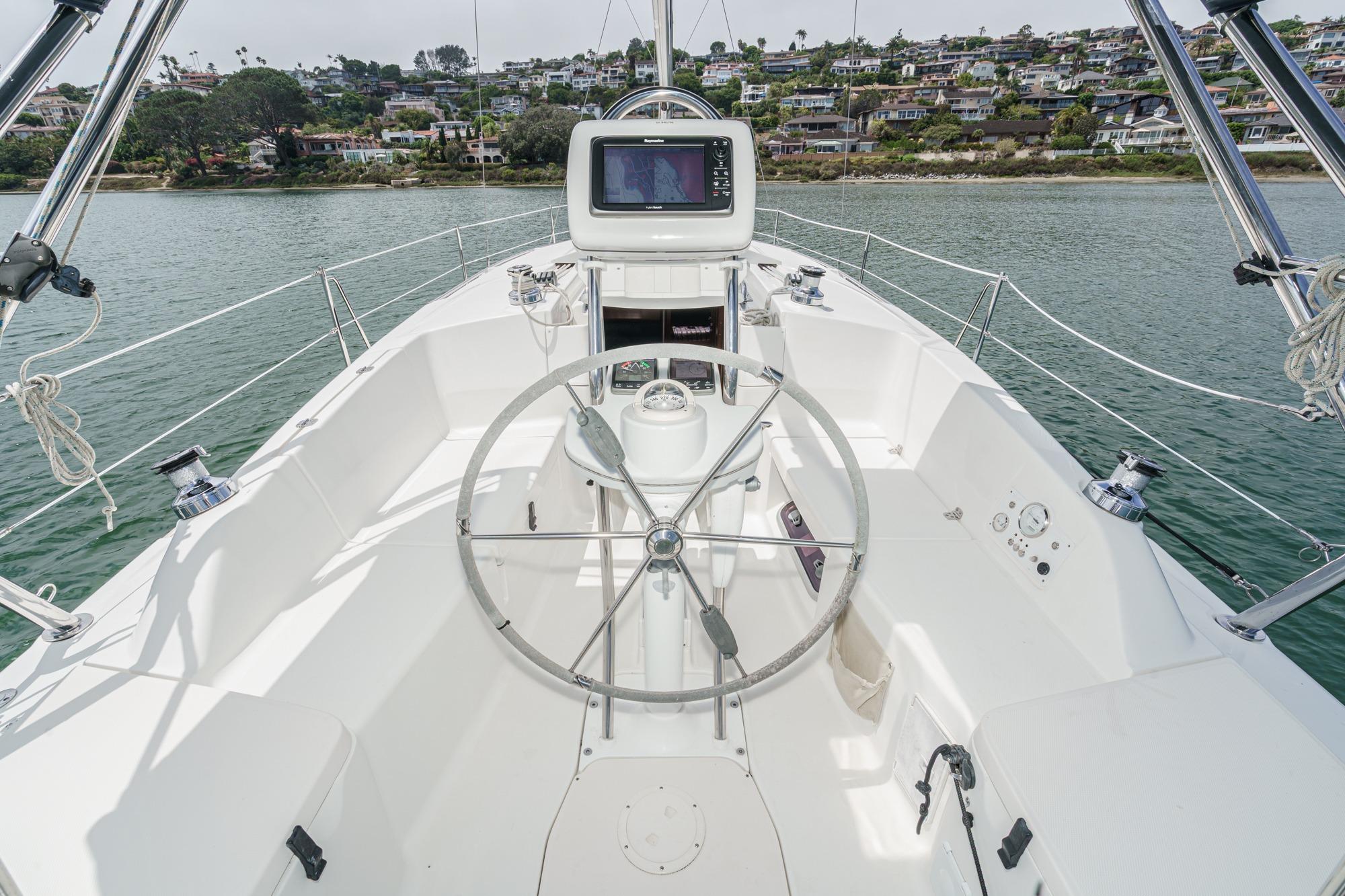 Cockpit view of 2015 Hunter 33 sailboat with steering wheel and navigation system.