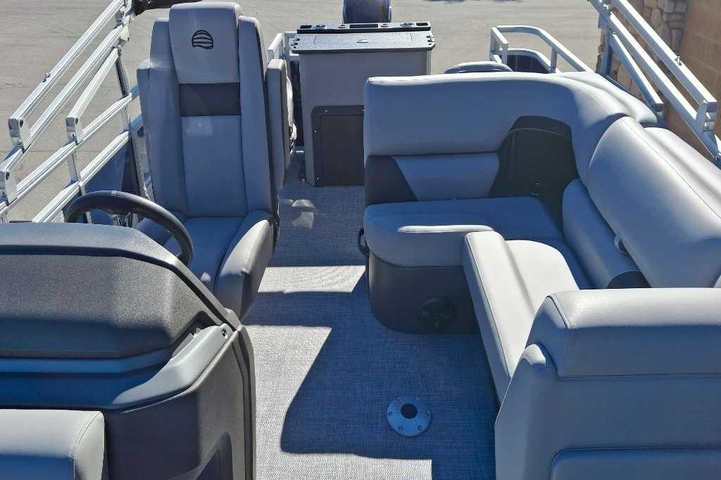 2026 Sun Tracker SportFish 20 DLX pontoon boat interior with plush seating and steering console.