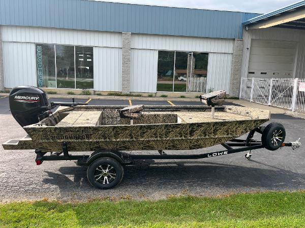 2024 Lowe Roughneck 1660 camo boat on trailer with Mercury outboard motor.