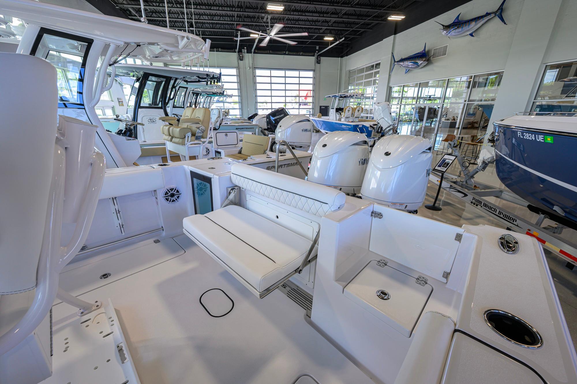 2026 Sportsman Open 252 Center Console boat interior in showroom with seating and engines.