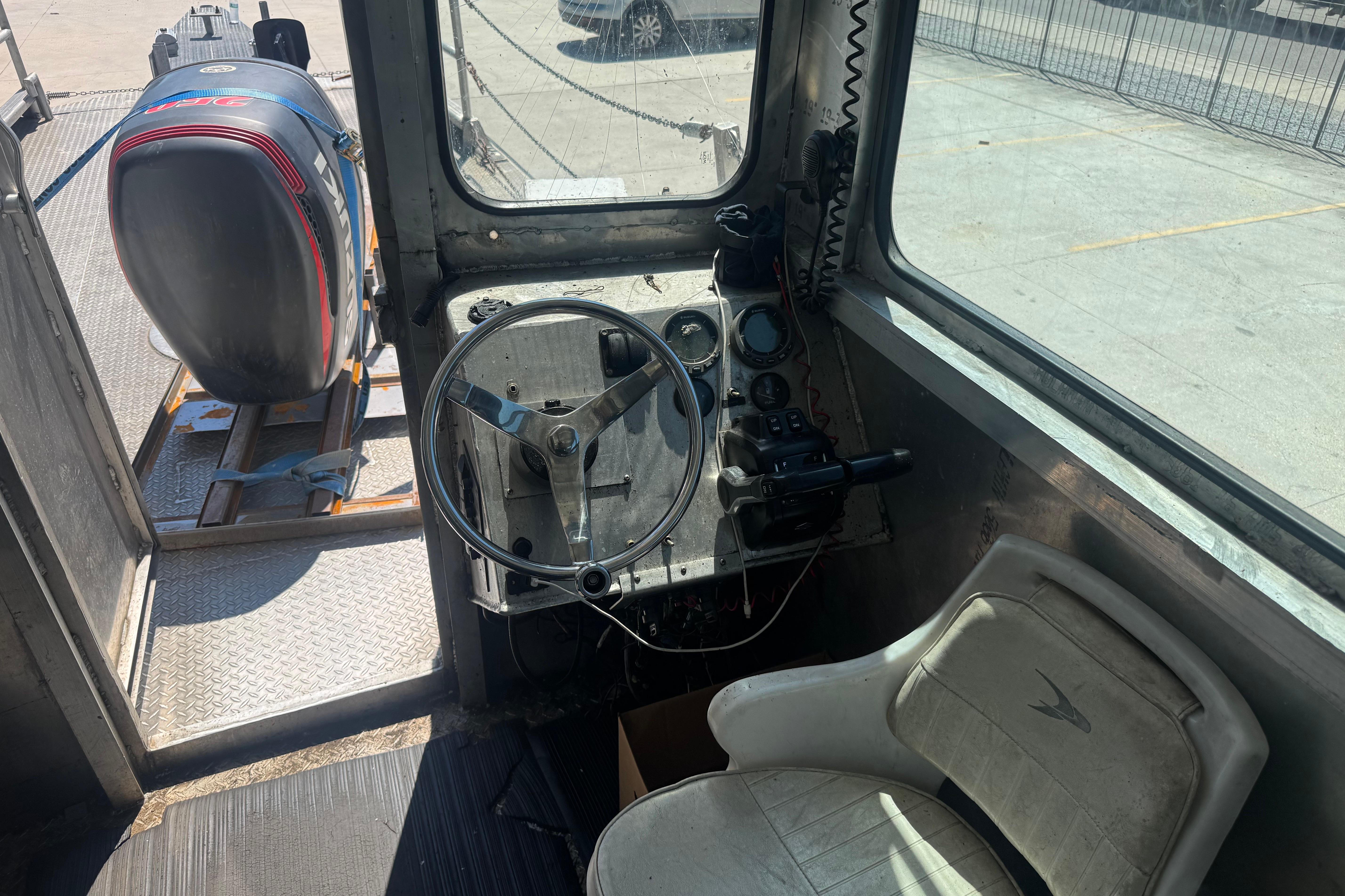 Interior of a 2010 Custom Aluminum Work Boat 33, featuring steering wheel and controls.