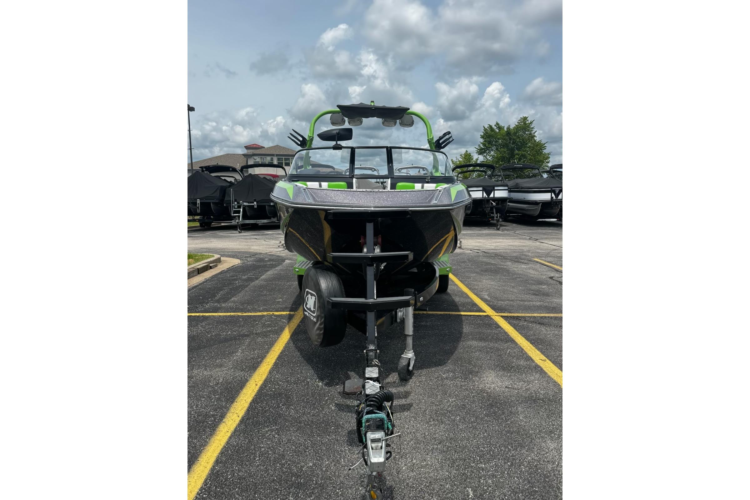 2014 Nautique Super Air Nautique G21 boat on trailer in parking lot.