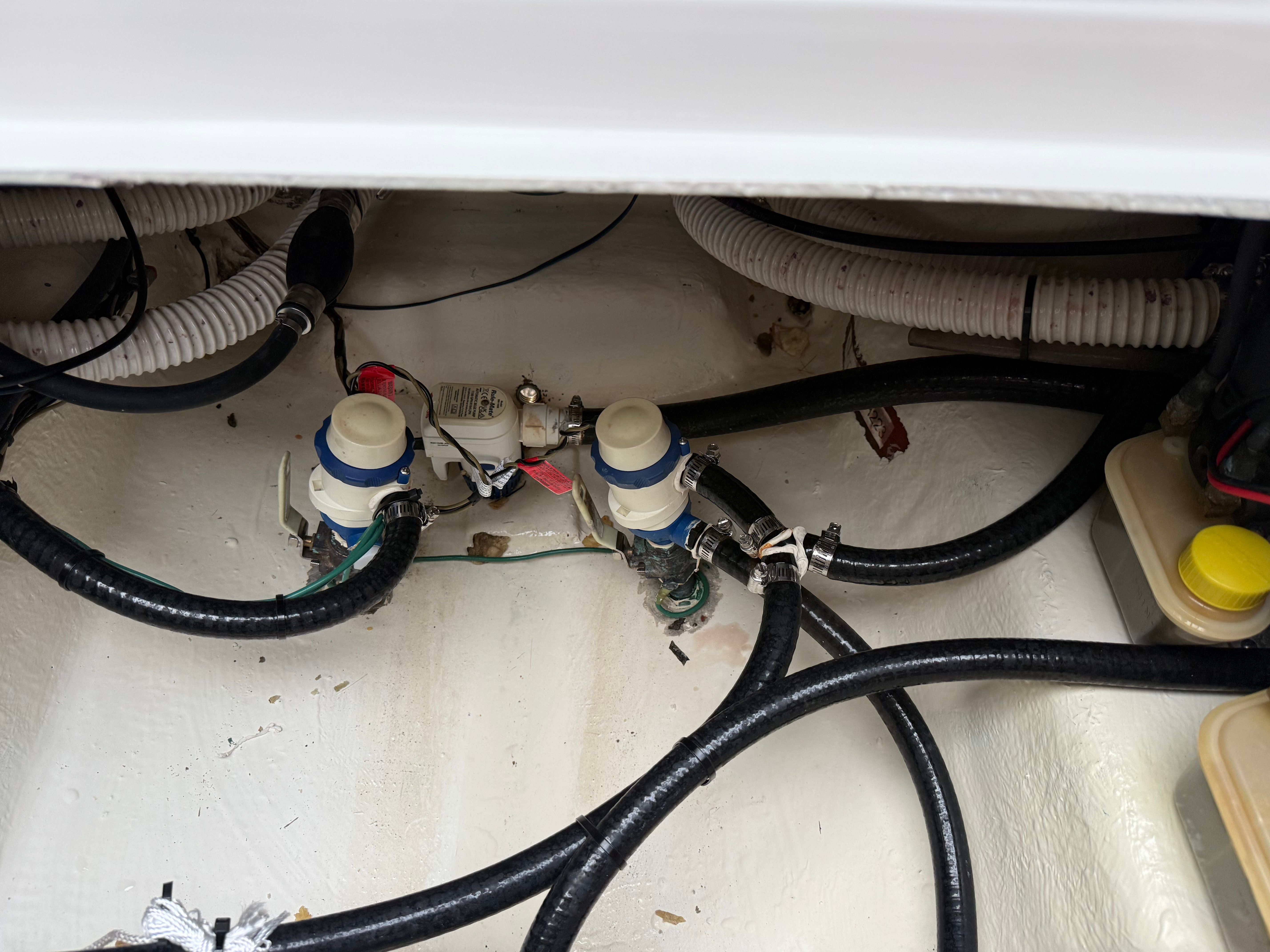 The image shows a boat's engine compartment with hoses and valves.