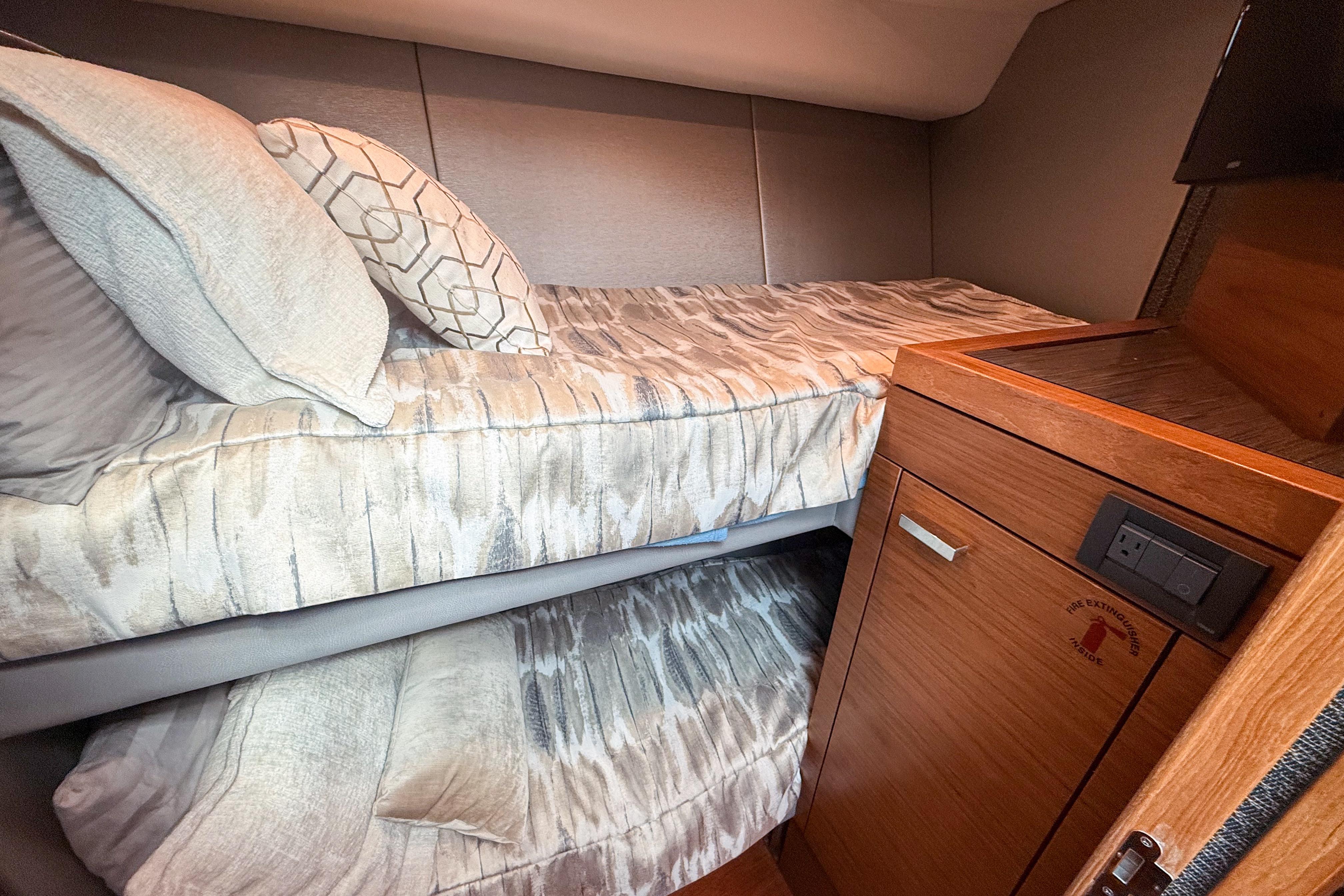 2019 Tiara Yachts F53 Flybridge cabin with cozy bunk beds and wooden cabinetry.