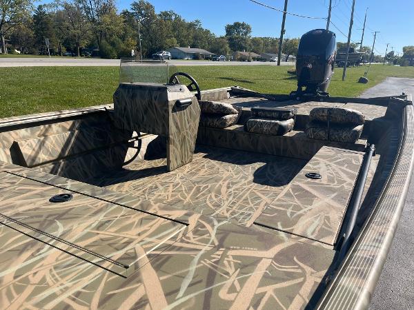 2025 Lowe Roughneck 2070 SC boat with camouflage design, parked on a sunny day.
