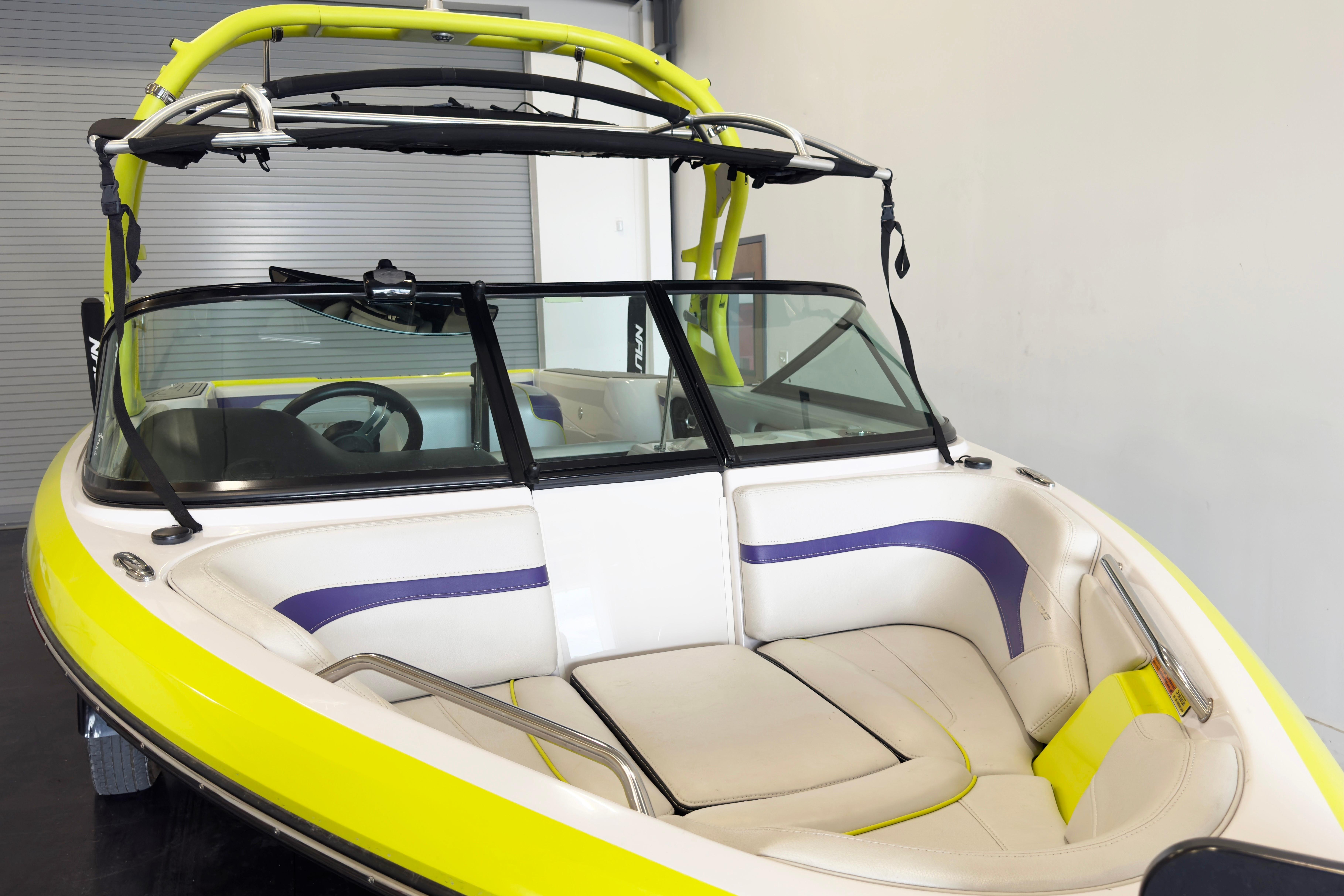 2014 Nautique Ski Nautique 200 Closed Bow boat with vibrant yellow and purple interior.