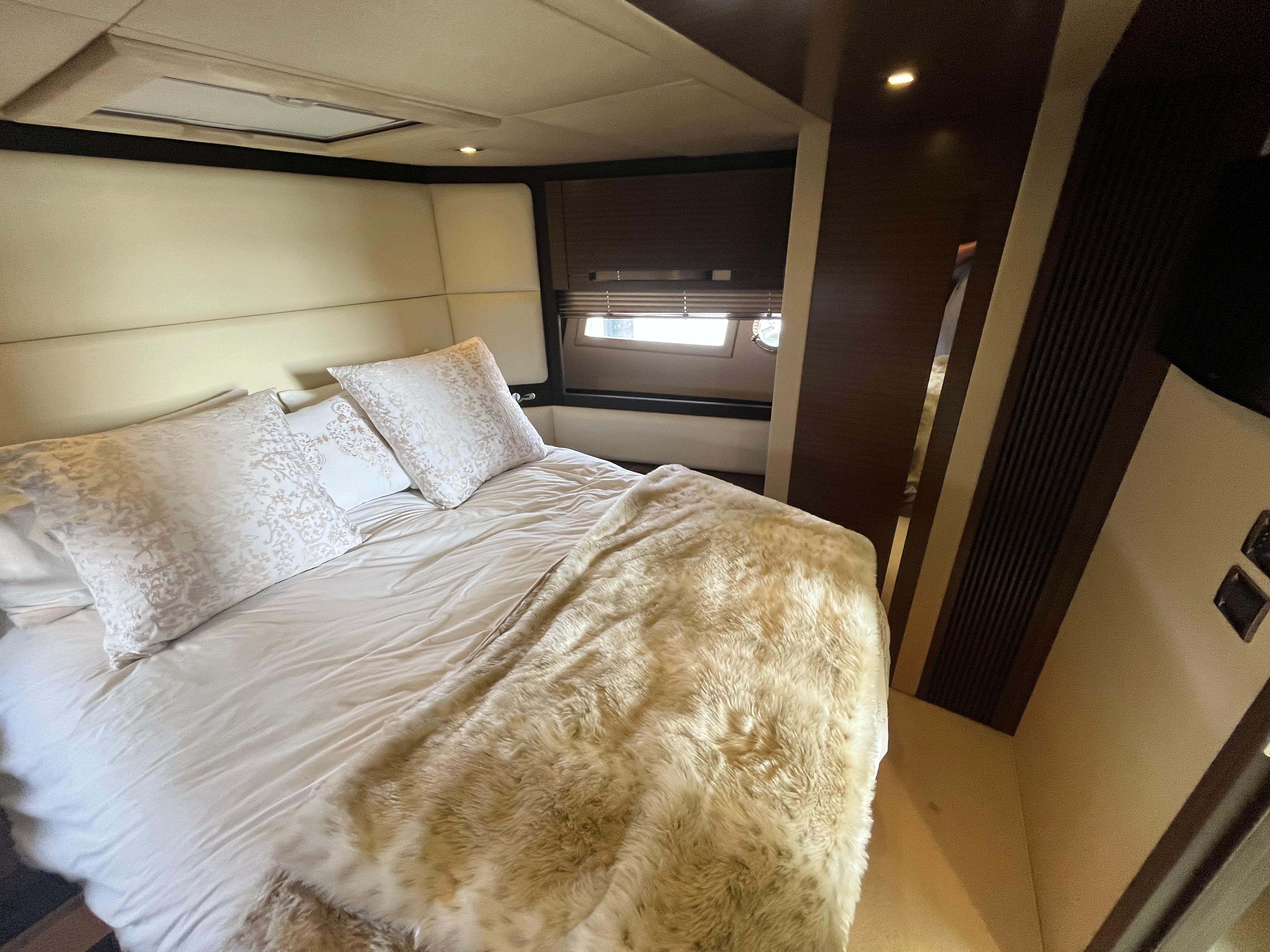 Luxurious bedroom interior of 2014 Azimut 55S yacht with plush bedding and elegant decor.