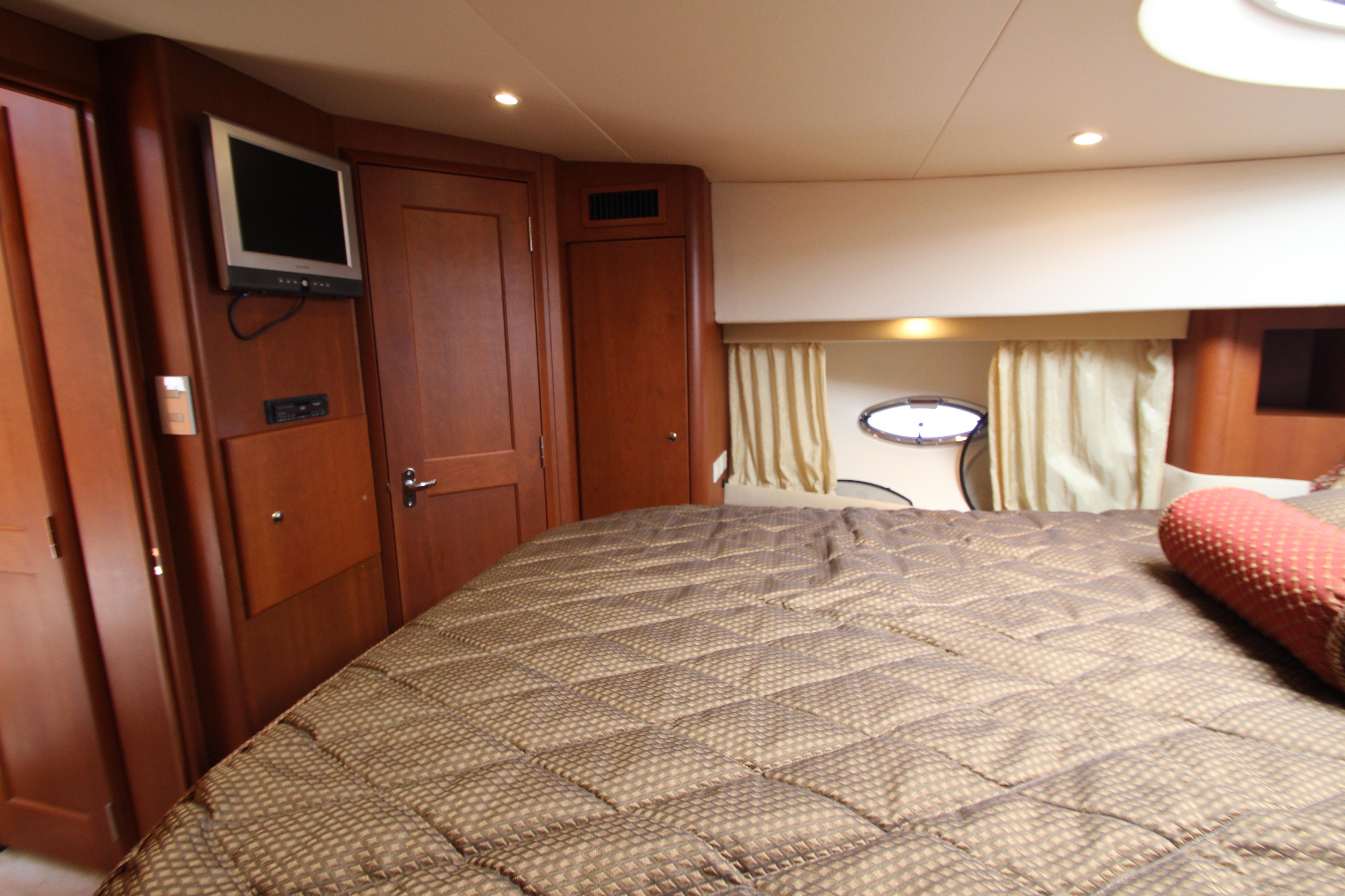 Luxurious cabin interior of 2006 Silverton 38 Sport Bridge yacht with cozy bedding.