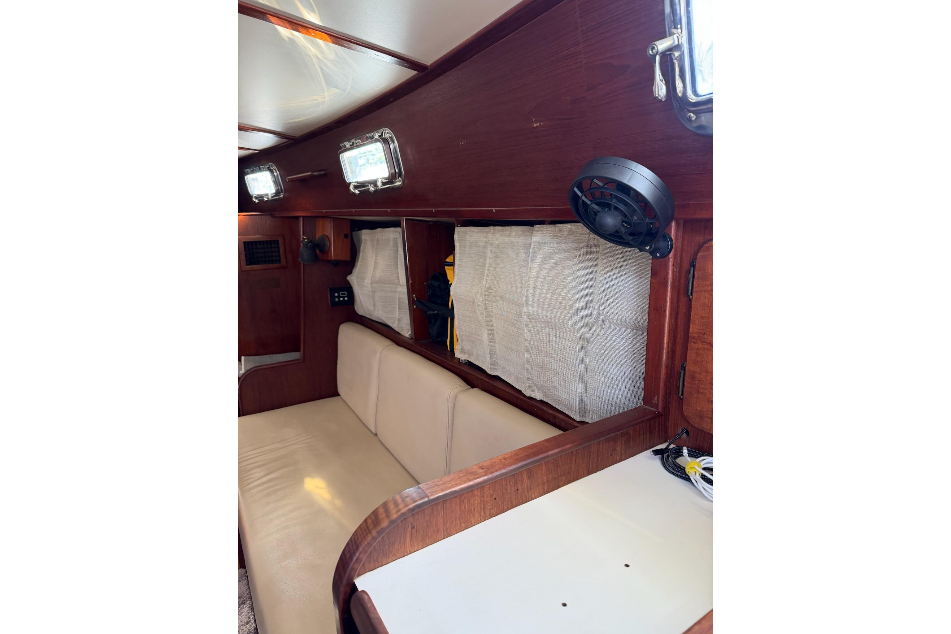 Interior of 1984 Morgan 384 sailboat with wooden paneling and beige seating.