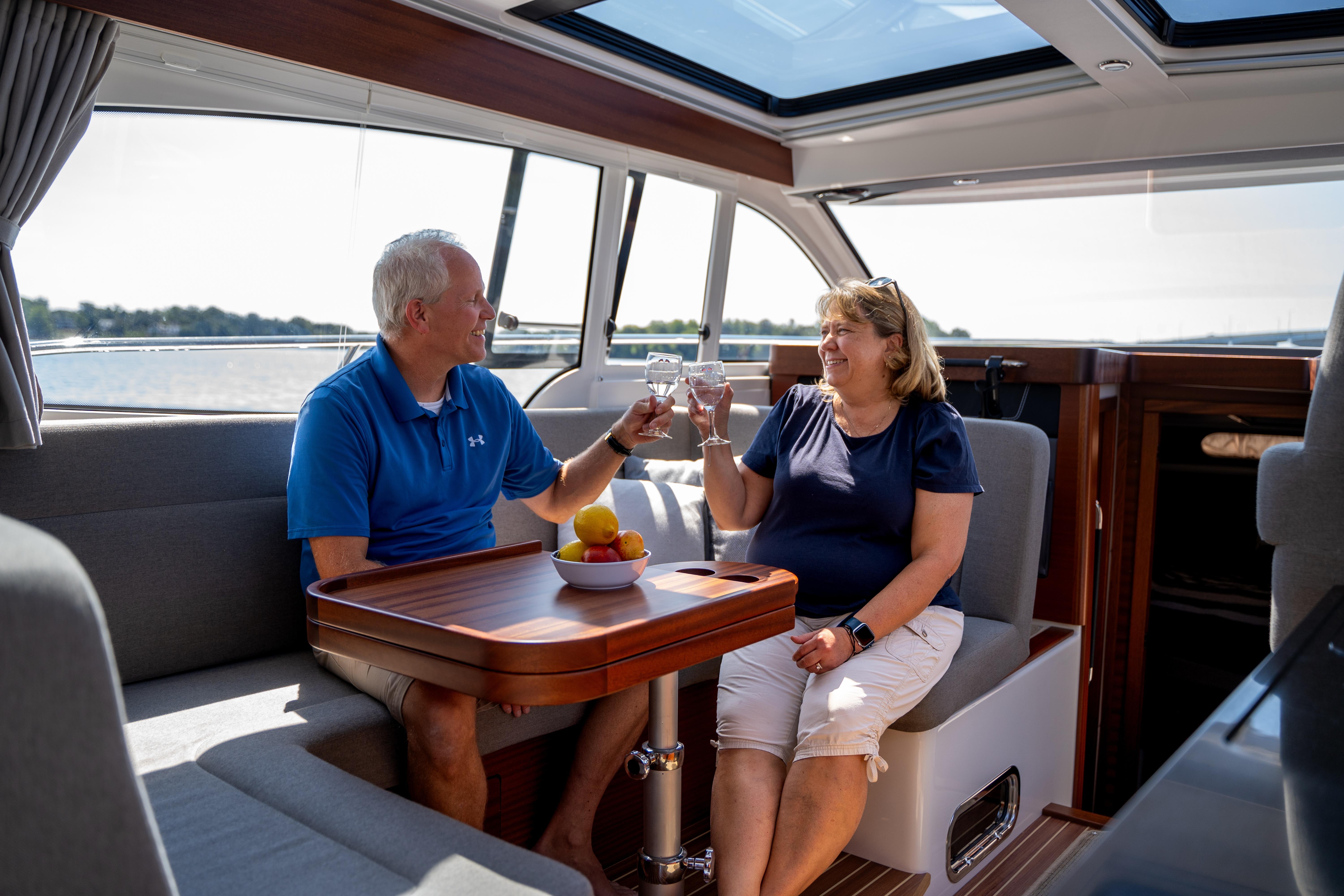 Couple enjoying drinks inside a 2026 Nimbus 365 Coupe yacht.