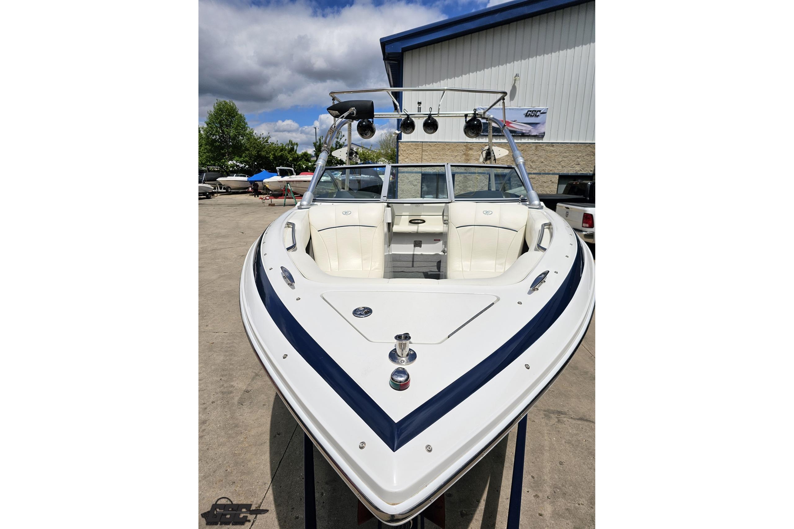 2010 Cobalt 232 WSS boat with sleek design, parked outdoors under a cloudy sky.