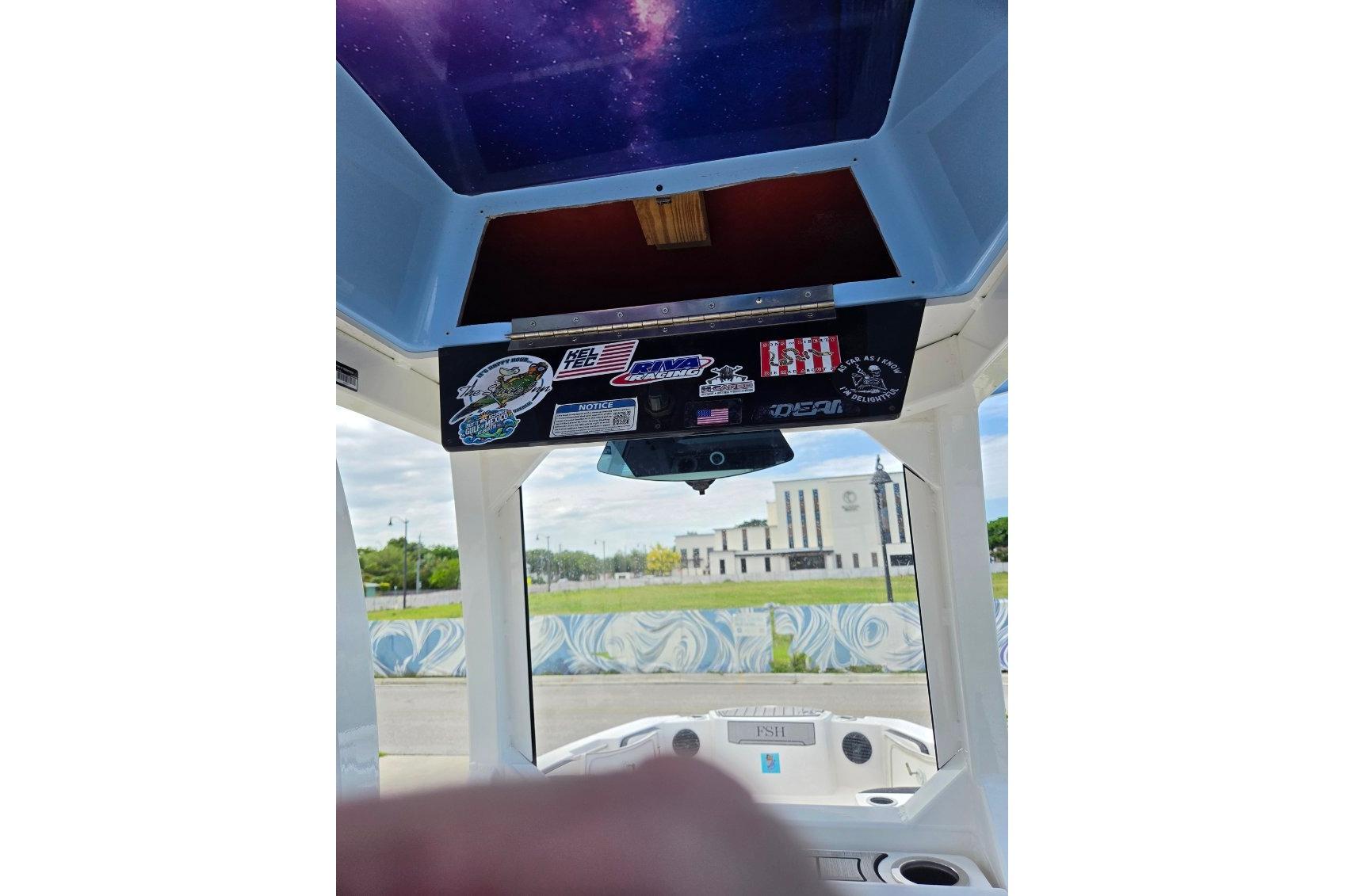 2024 Yamaha Boats 222 FSH Sport E dashboard with stickers and scenic background.