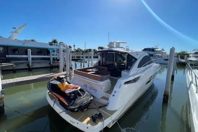 2016 Sea Ray Sundancer 510 yacht docked with jet ski on platform.