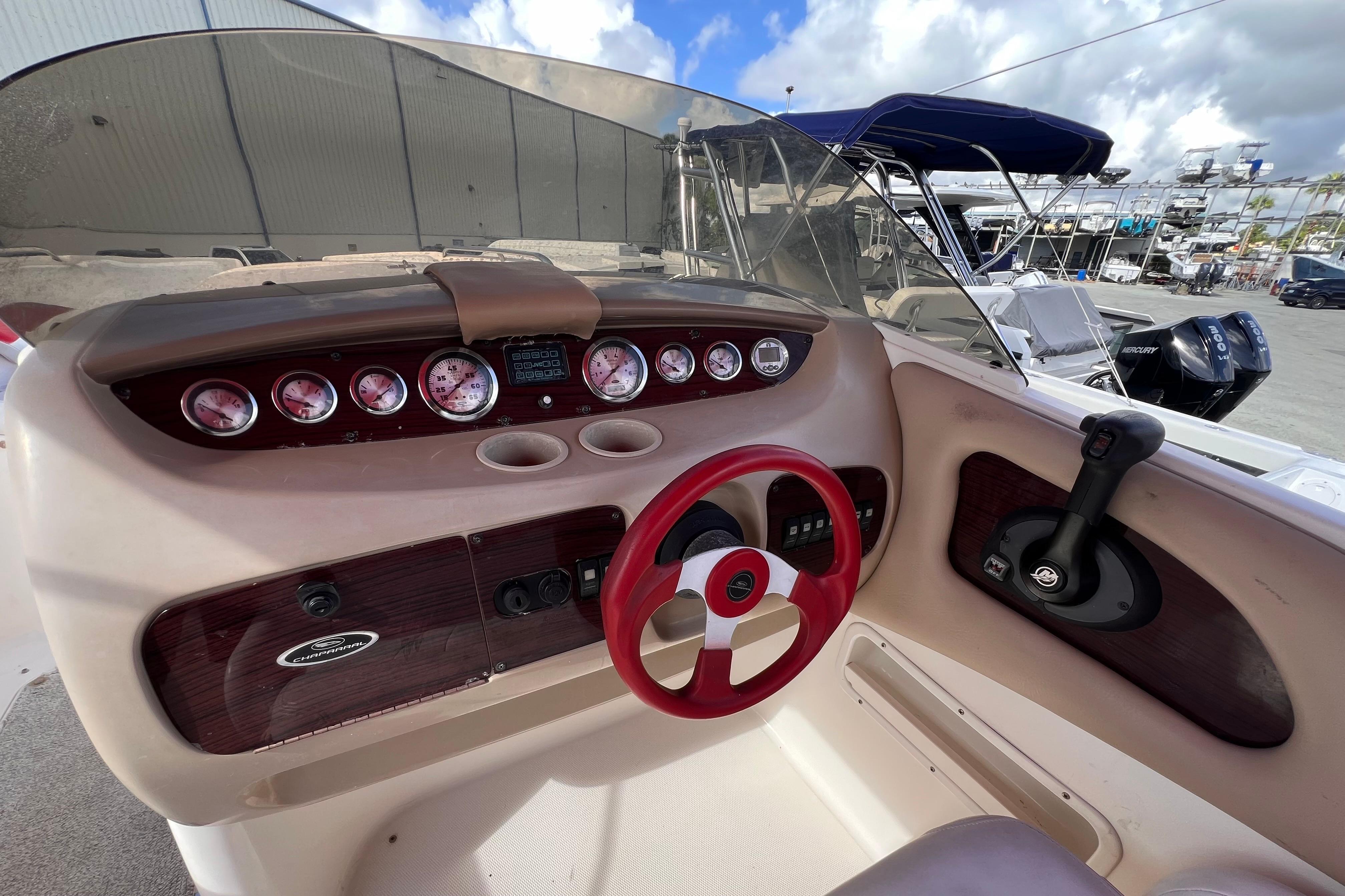 2002 Chaparral 232 Sunesta boat dashboard with red steering wheel and gauges.