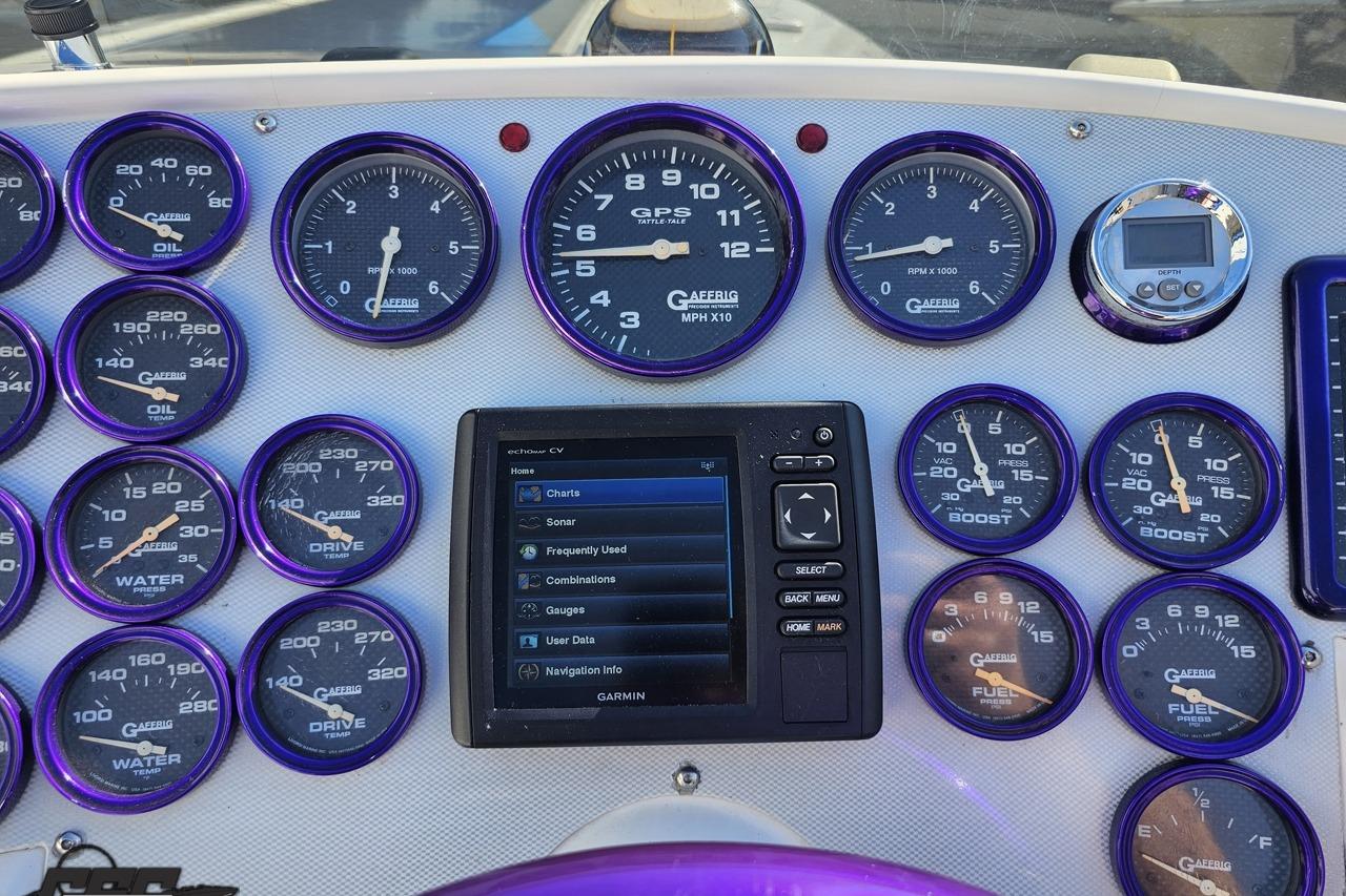 Dashboard of a 2002 Hustler 388 SLINGSHOT with gauges and Garmin display.