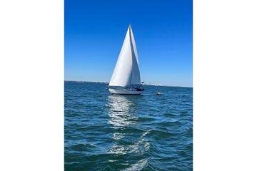 Sailboat on open water, Reliance 44 model, 2011, under clear blue sky.