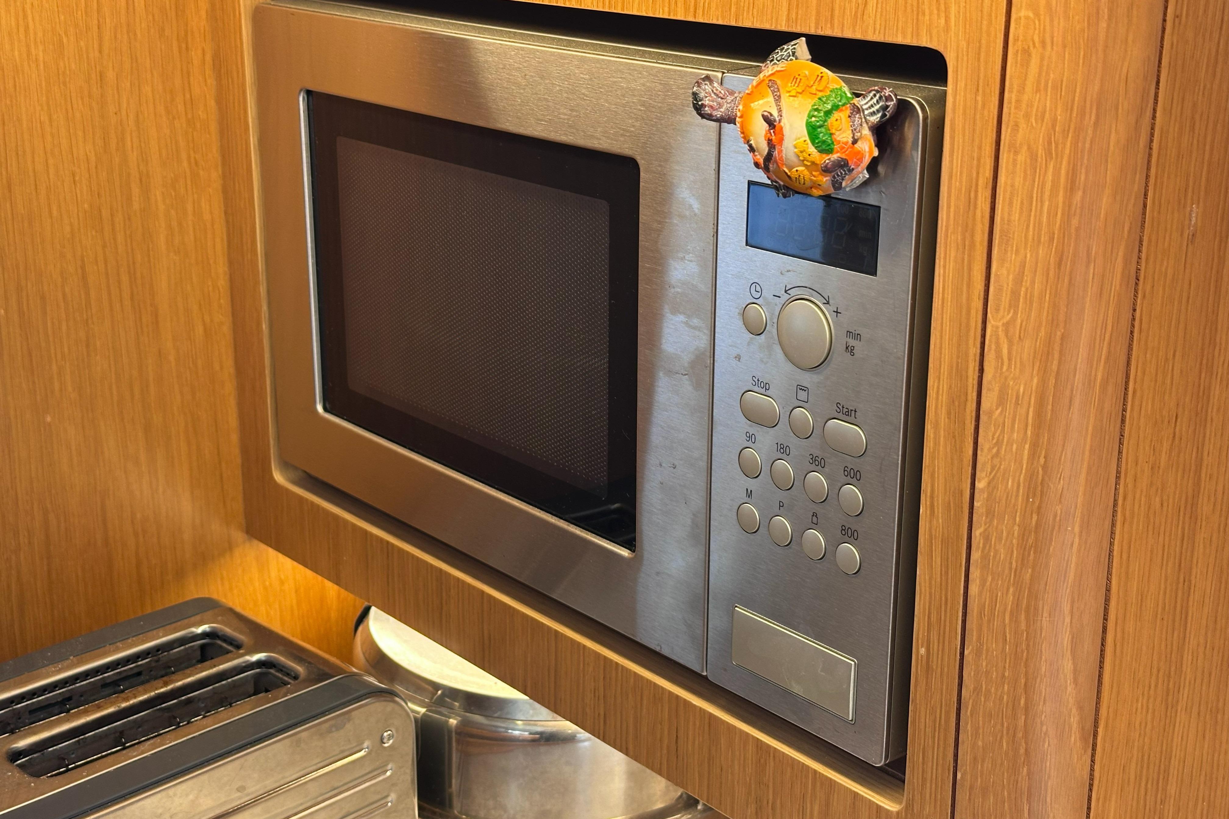Built-in microwave on Hallberg-Rassy 48 MkII yacht, 2020 model, with wooden cabinetry.