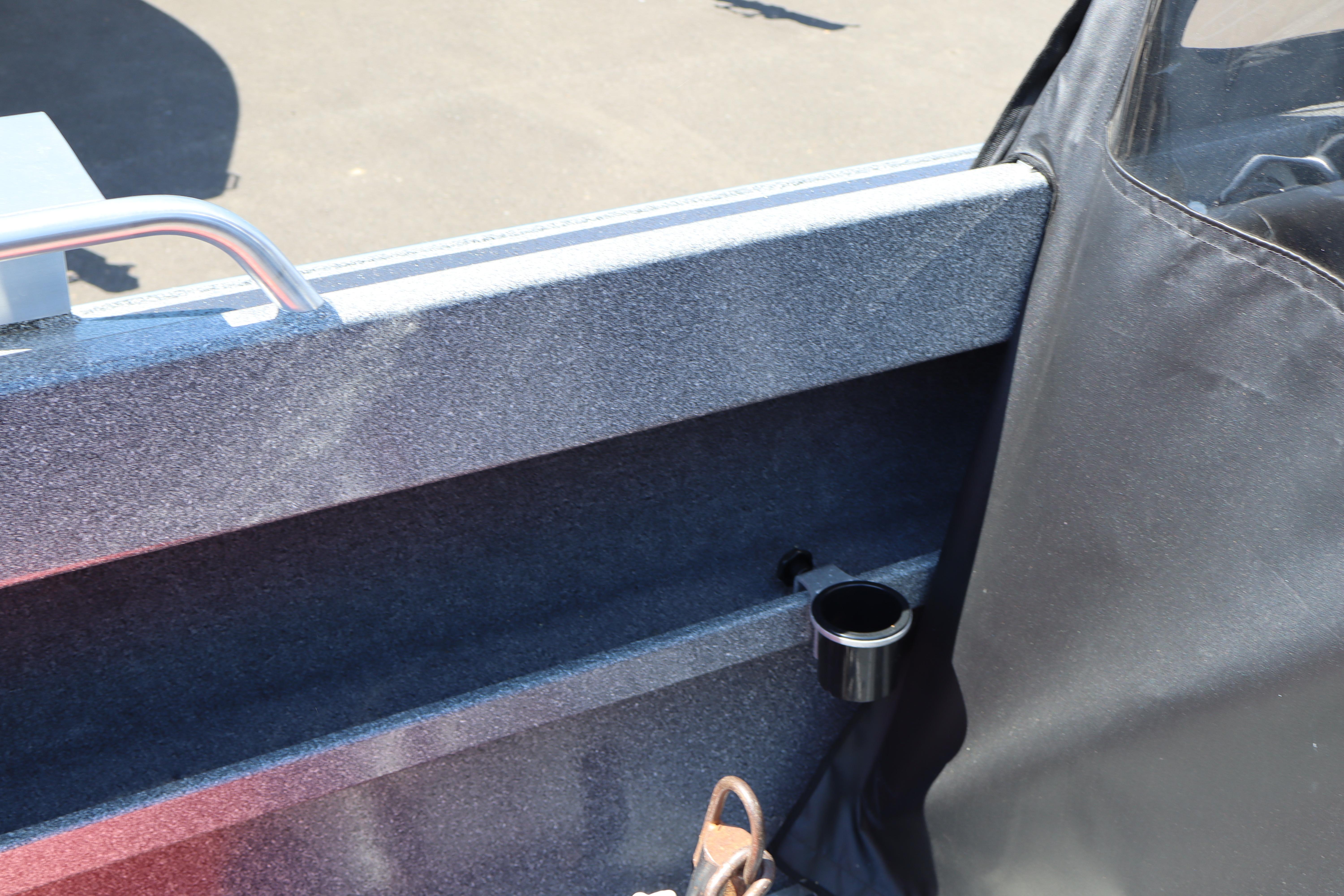 Interior detail of 2025 NorthRiver SEAHAWK boat, featuring a cup holder and railing.