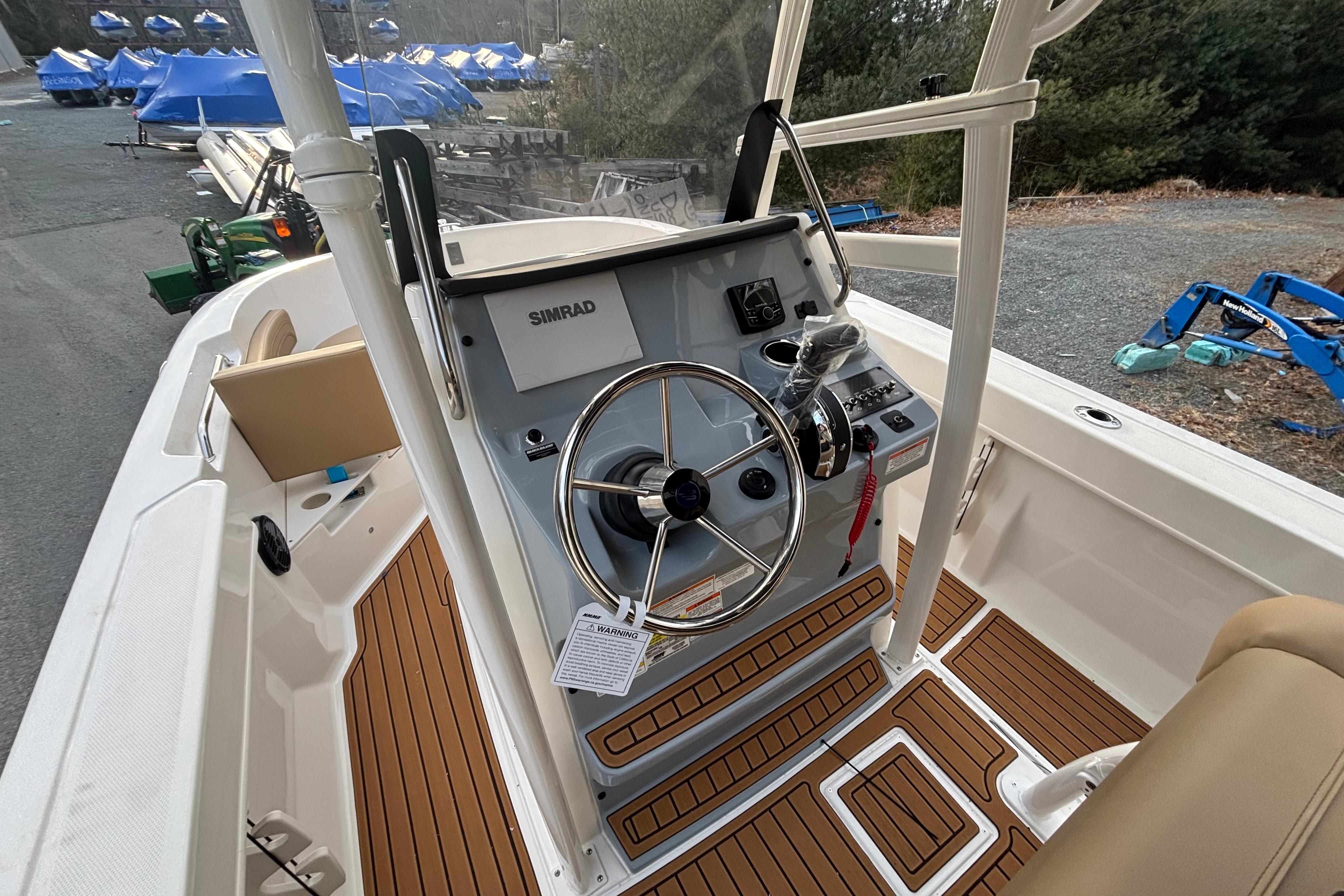 2026 Bayliner Trophy T20CC boat helm with Simrad electronics and teak flooring.