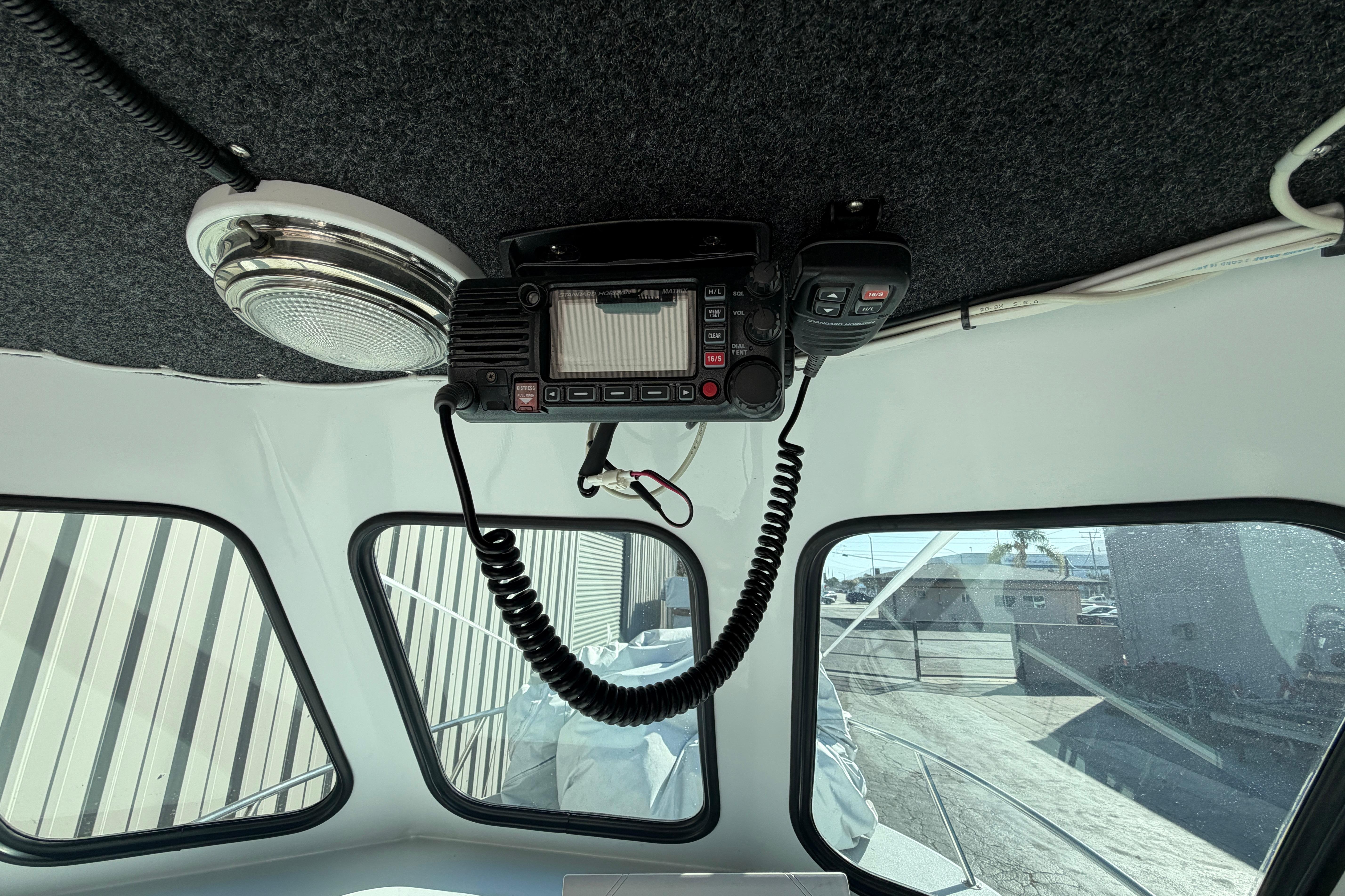 Interior of a 1986 Radon 21 Sport boat with radio equipment and windows.