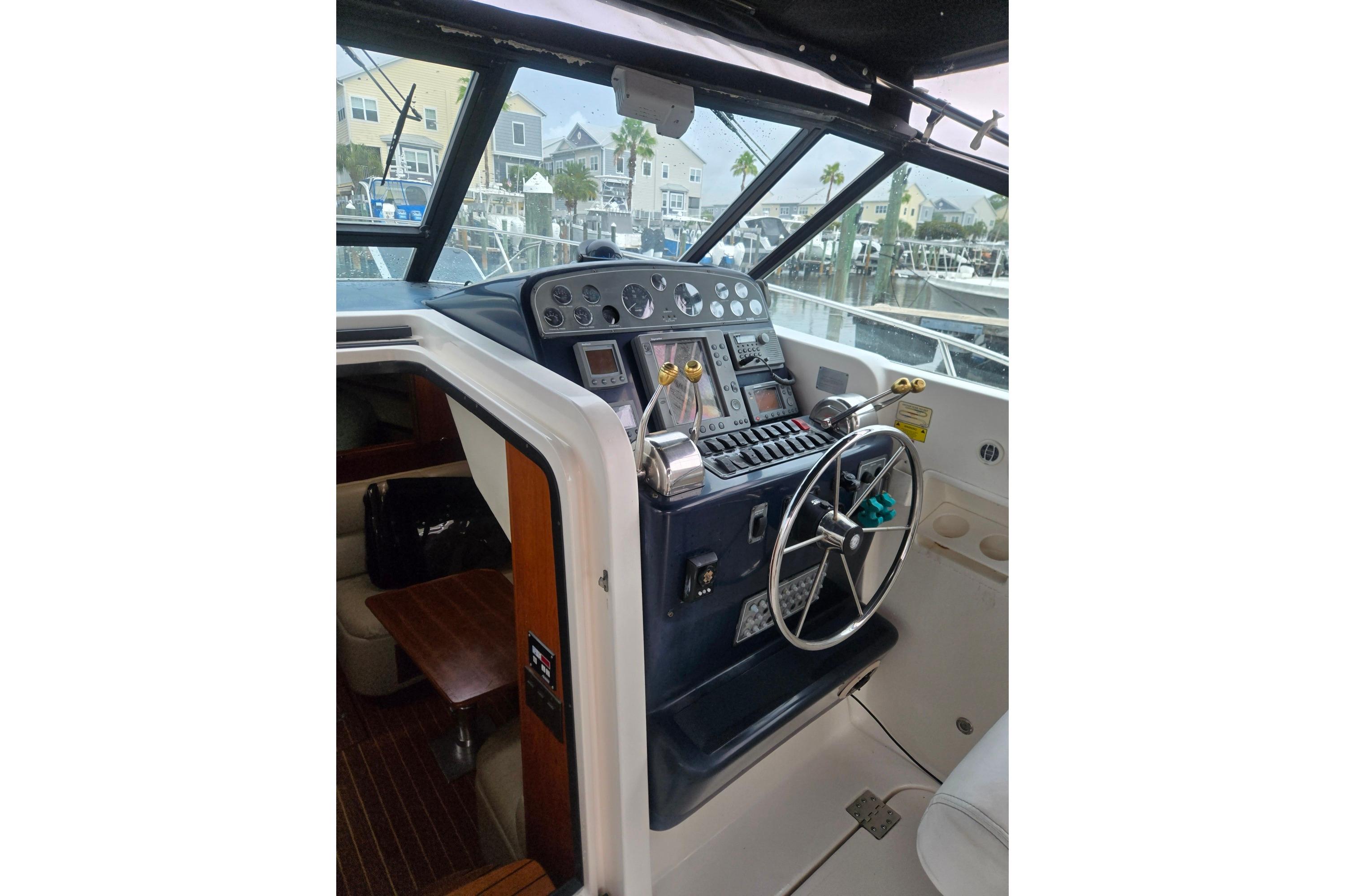 Helm of 2002 Tiara Yachts 3500 Open with steering wheel and control panel.
