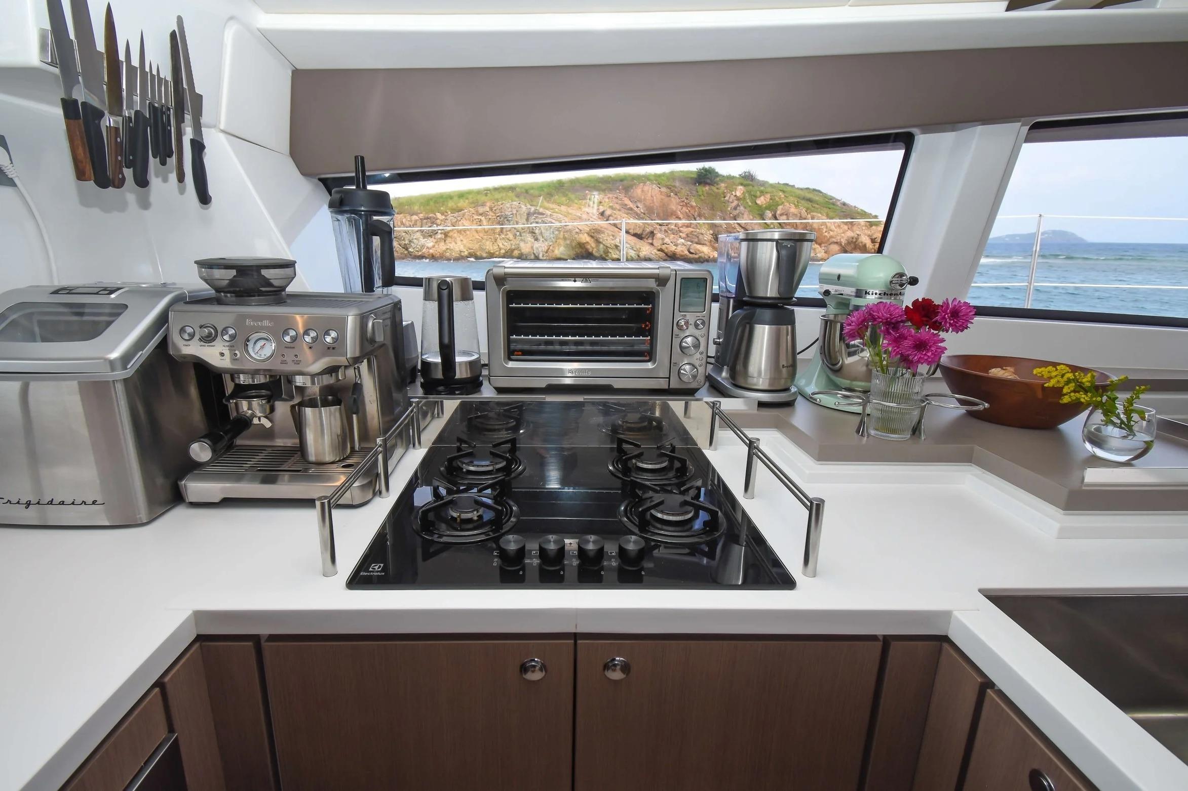 Modern kitchen in a 2022 Bali 5.4 yacht with appliances and ocean view.