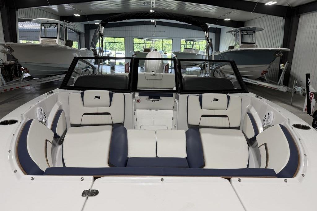 2027 Stingray 20 SBX boat interior with white and navy seating in a showroom.