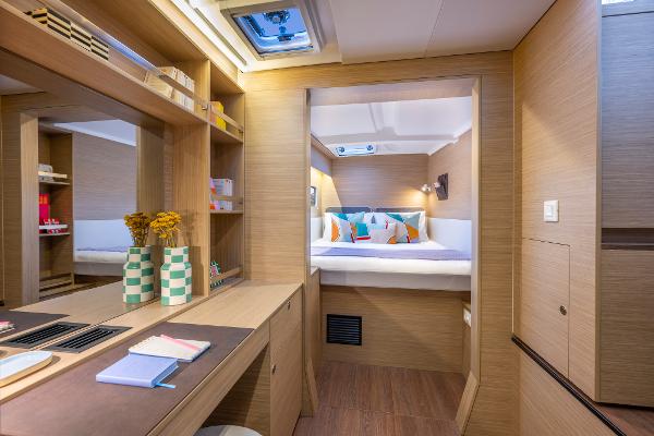 Luxurious interior of 2025 Lagoon 38 catamaran with cozy bedroom and modern decor.